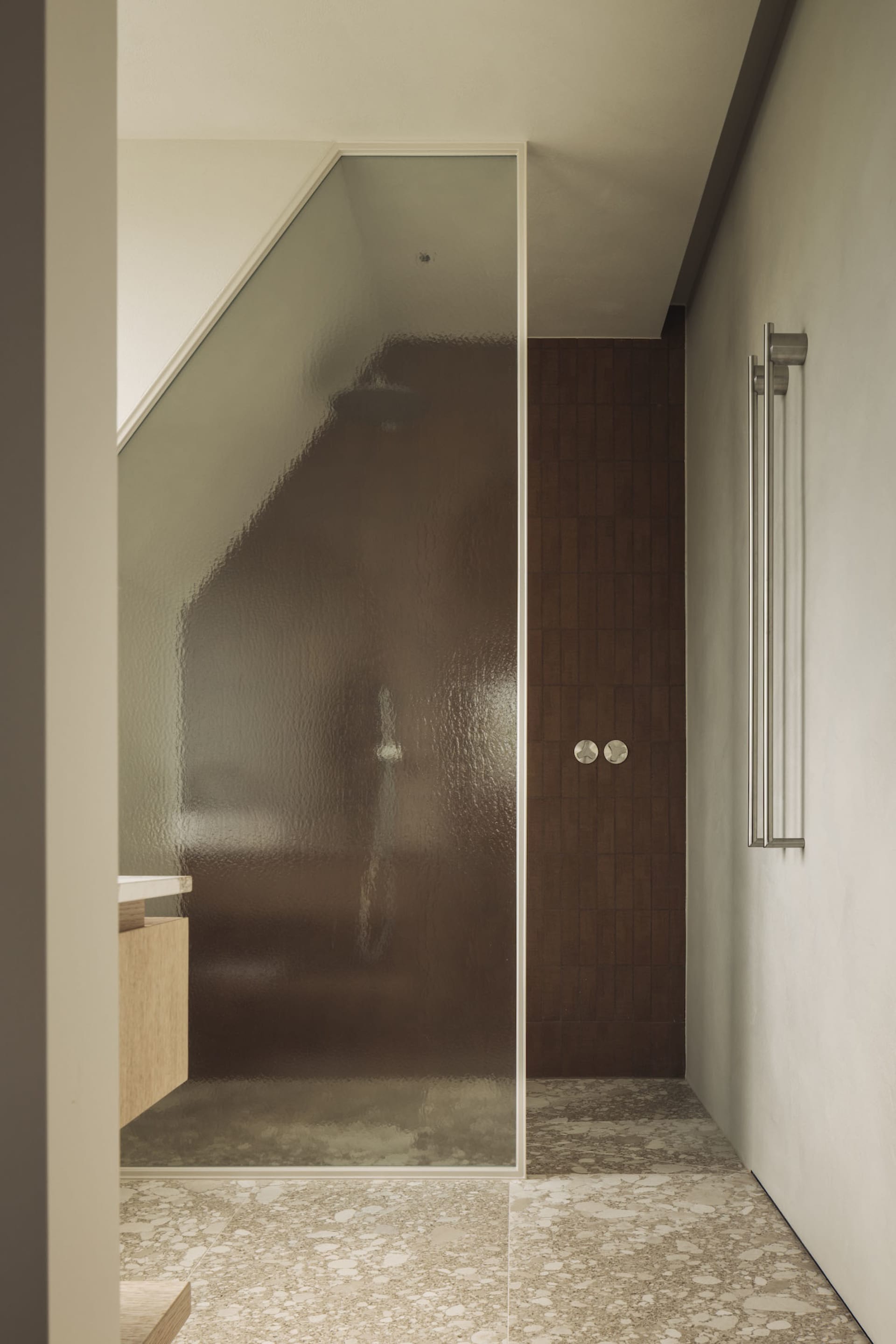 A well-lit bathroom with a glass shower door and brown wood trim, creating an inviting atmosphere