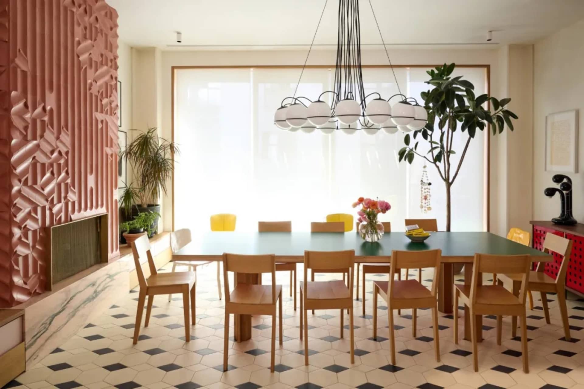 A dining area with a wooden table and chairs, surrounded by potted plants, creating a cozy atmosphere