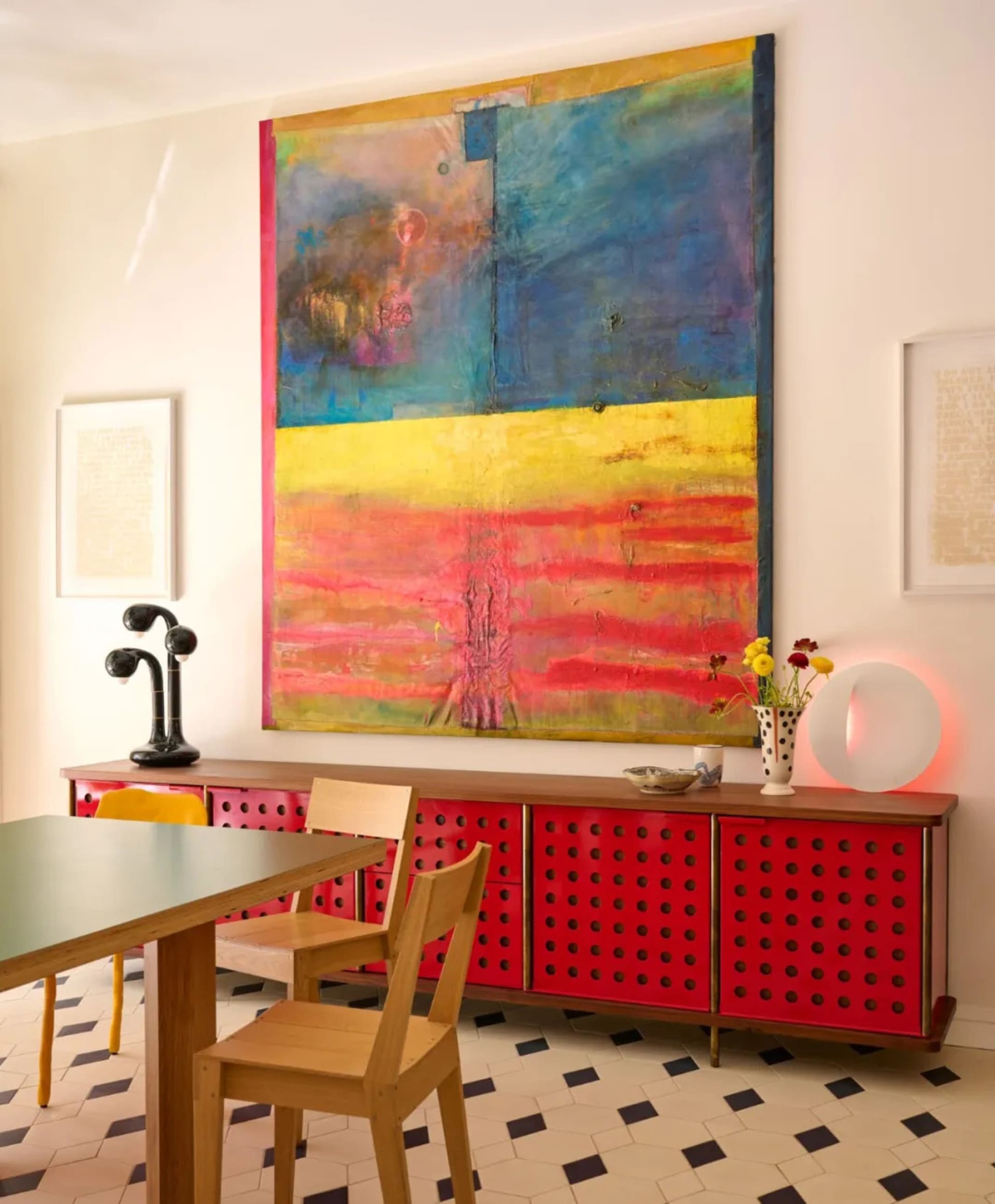 A modern dining space with a red and white color scheme, a dining table, and two chairs, set against a clean and minimalistic background