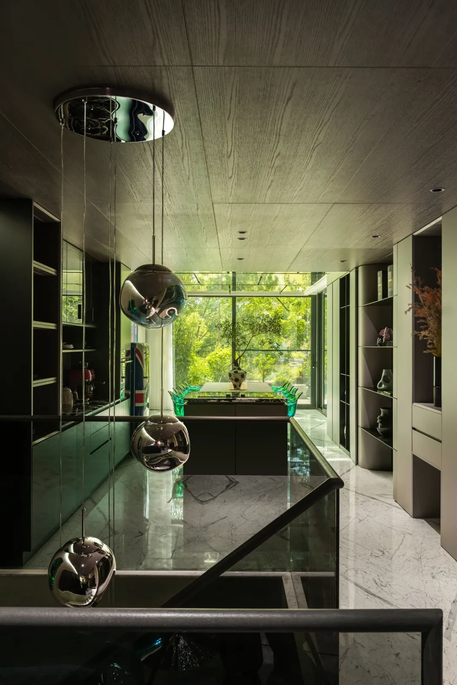 Sleek modern kitchen and dining area with a large island, potted plants, and a long dining table