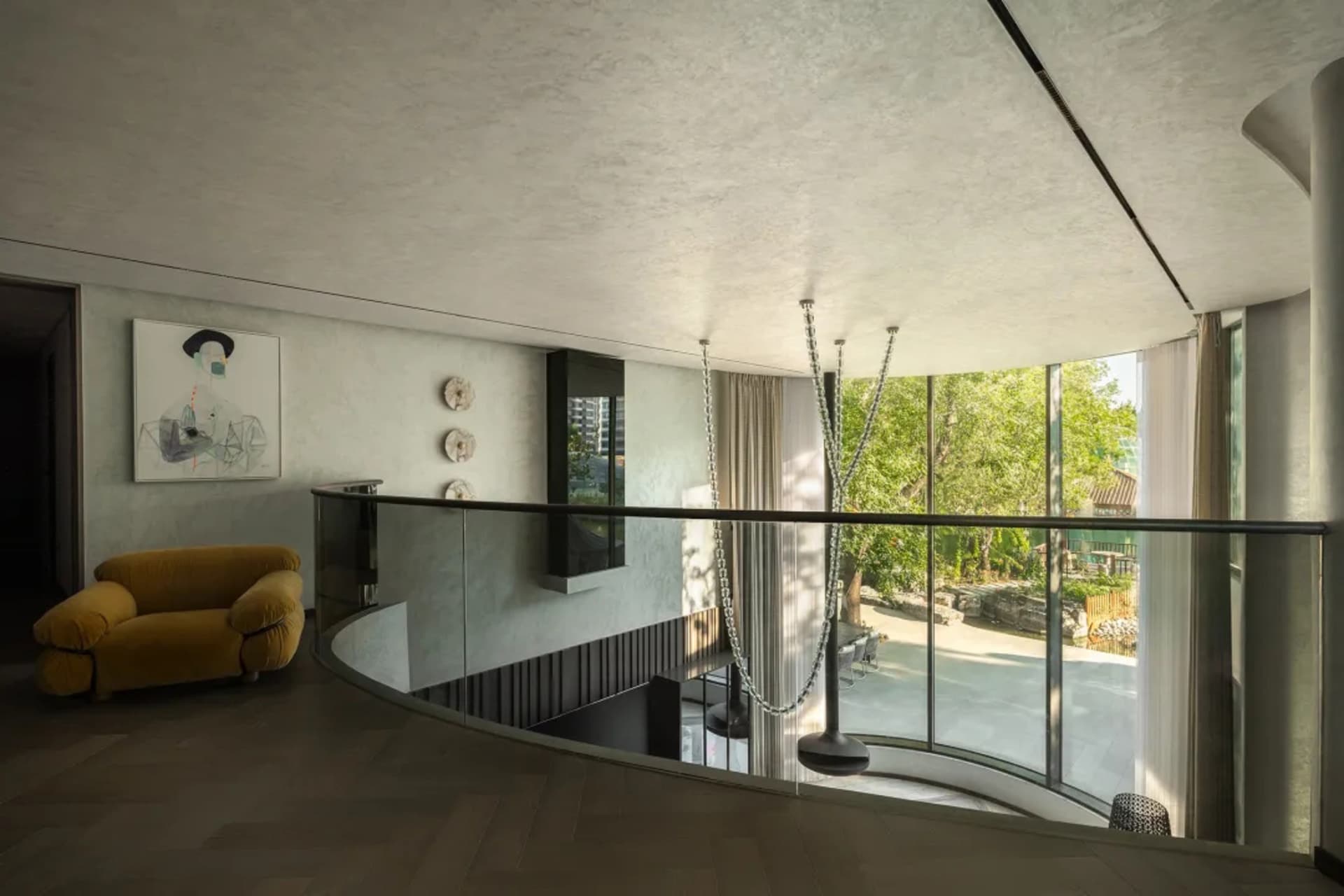 Open living area with a large window, two chairs, and a couch, creating a spacious and inviting atmosphere