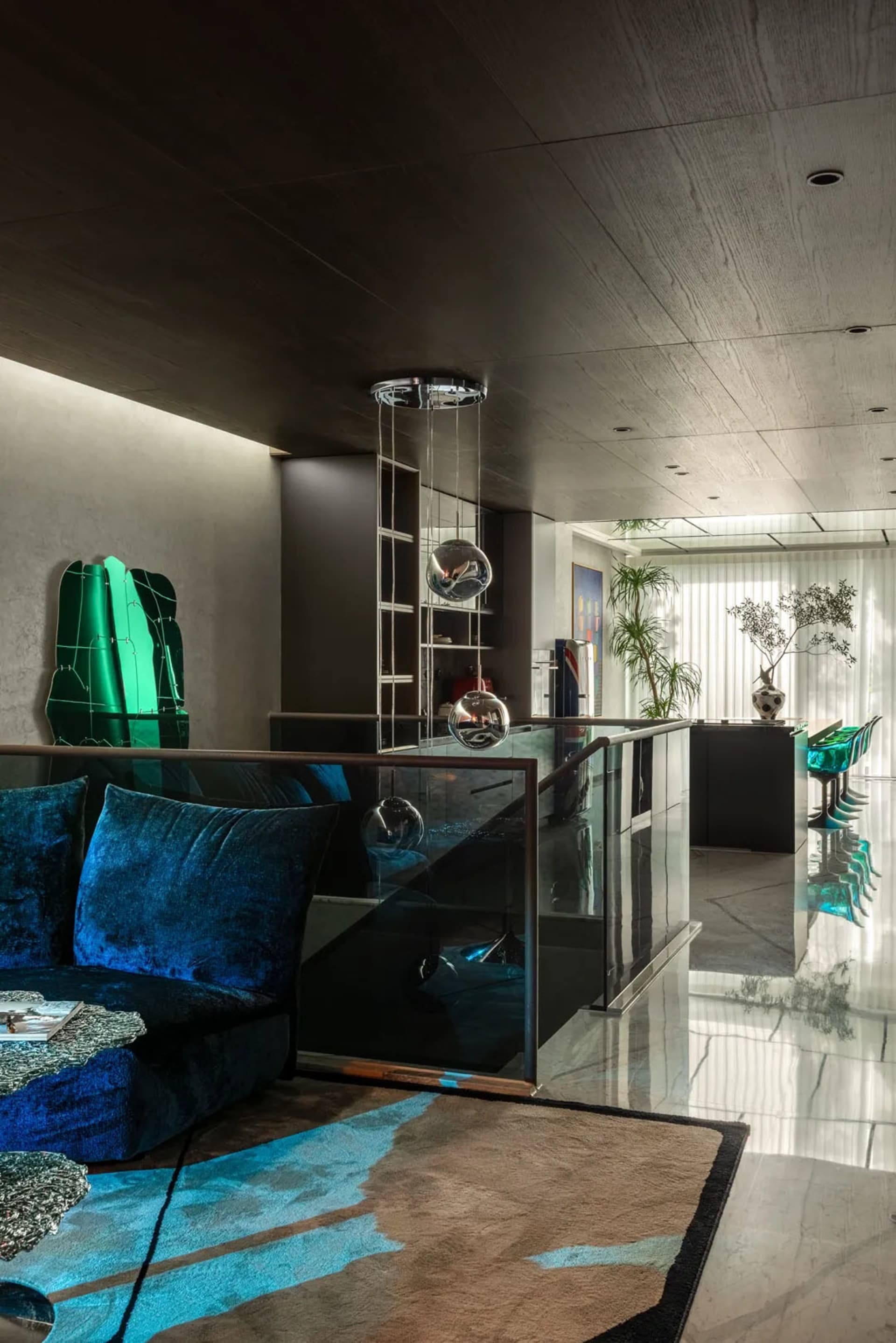 Open living and dining area with a glass wall, natural light, a couch, dining table, chairs, and potted plants