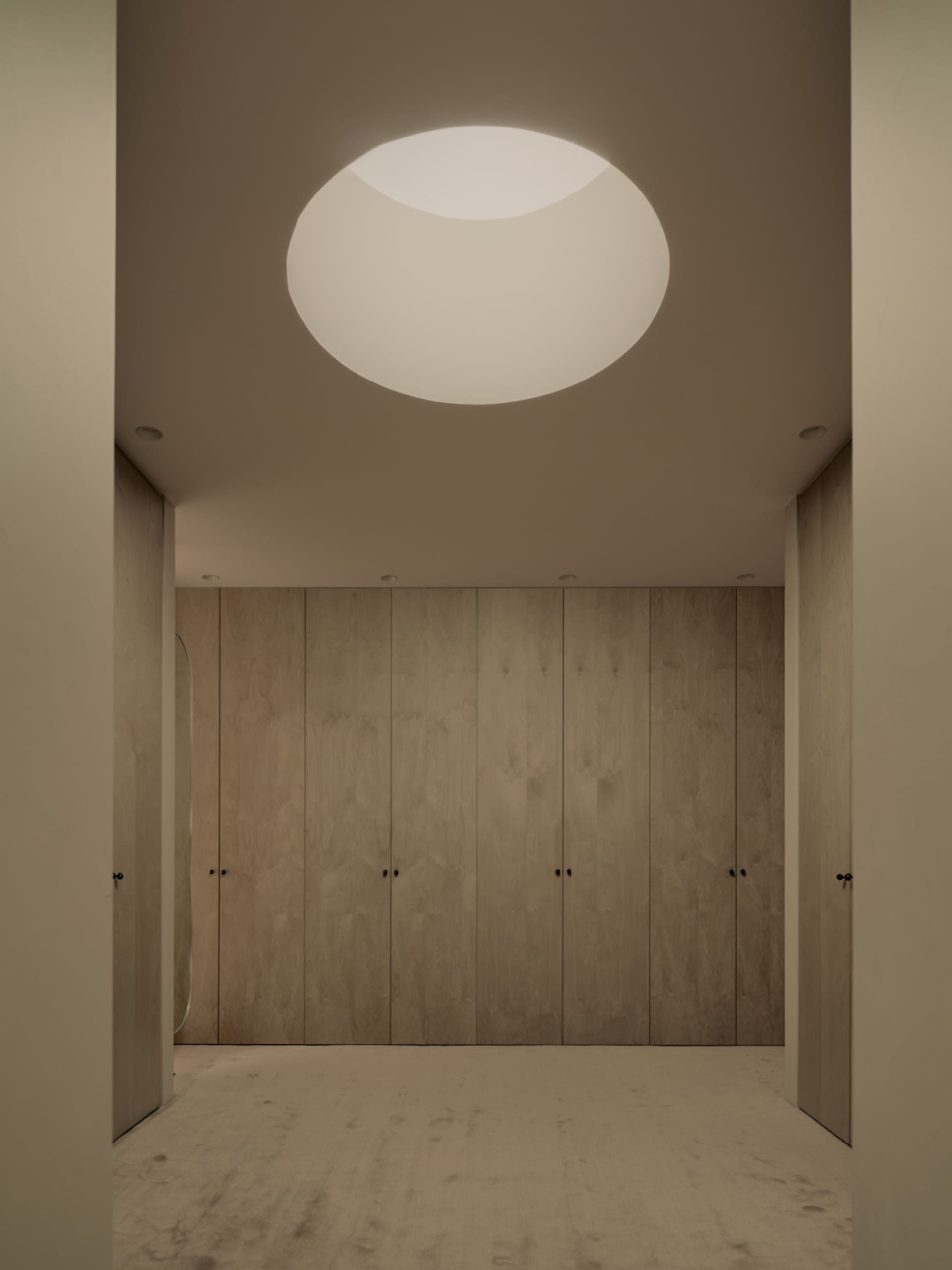 Empty room with wooden walls and ceiling, two doors, and a warm and cozy atmosphere