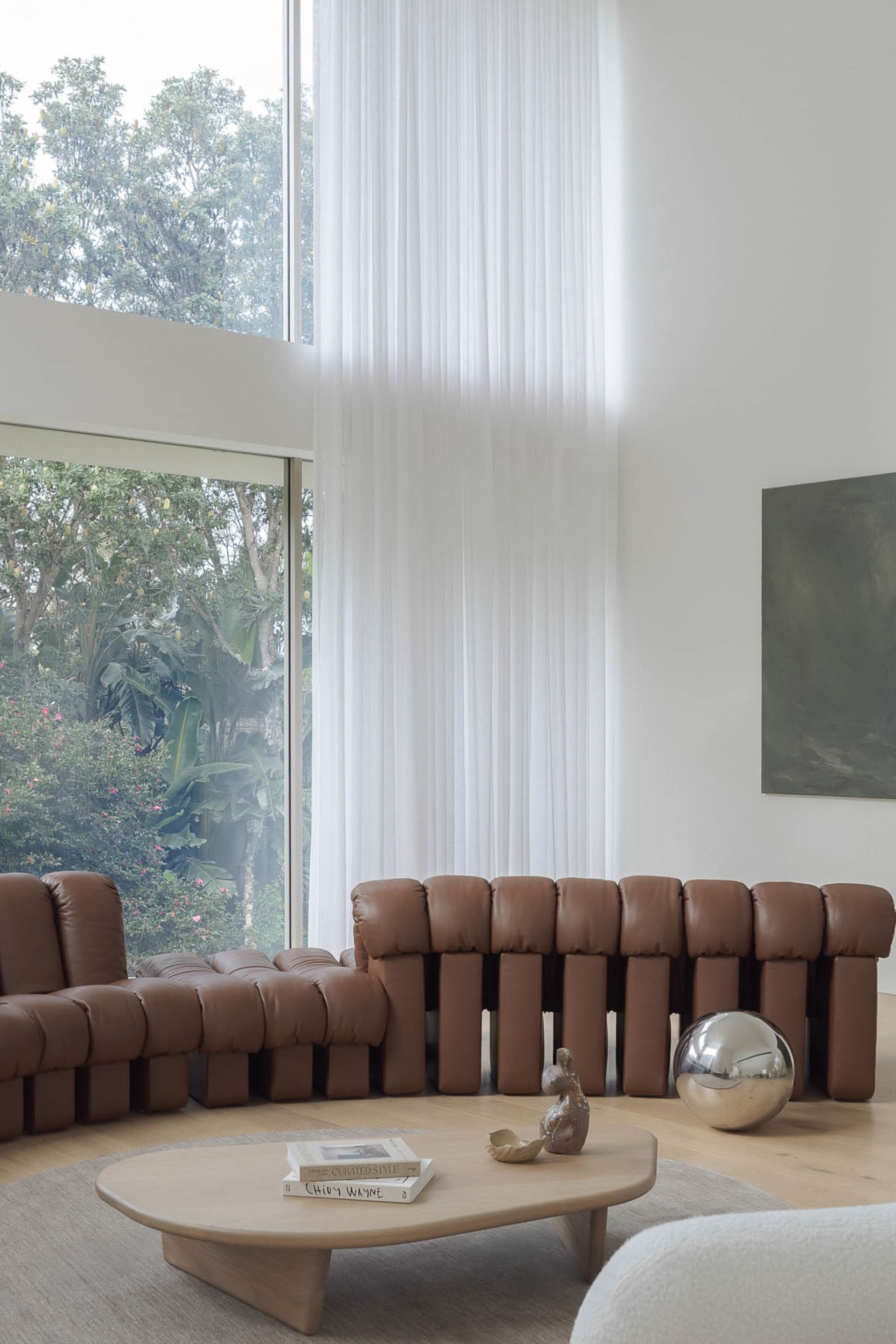 Modern living room with white walls, brown leather furniture, and a clean minimalistic atmosphere