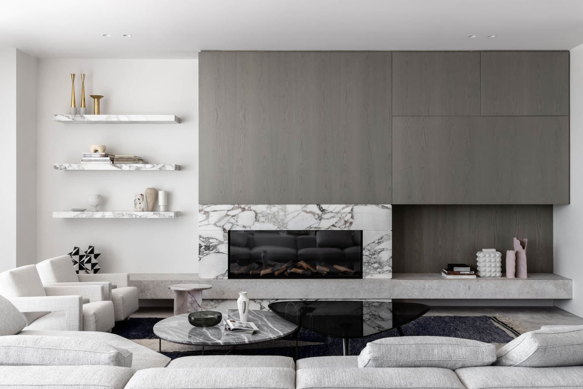 Cozy modern living space with a fireplace, comfortable seating, and books, surrounded by clean lines and minimalistic decoration