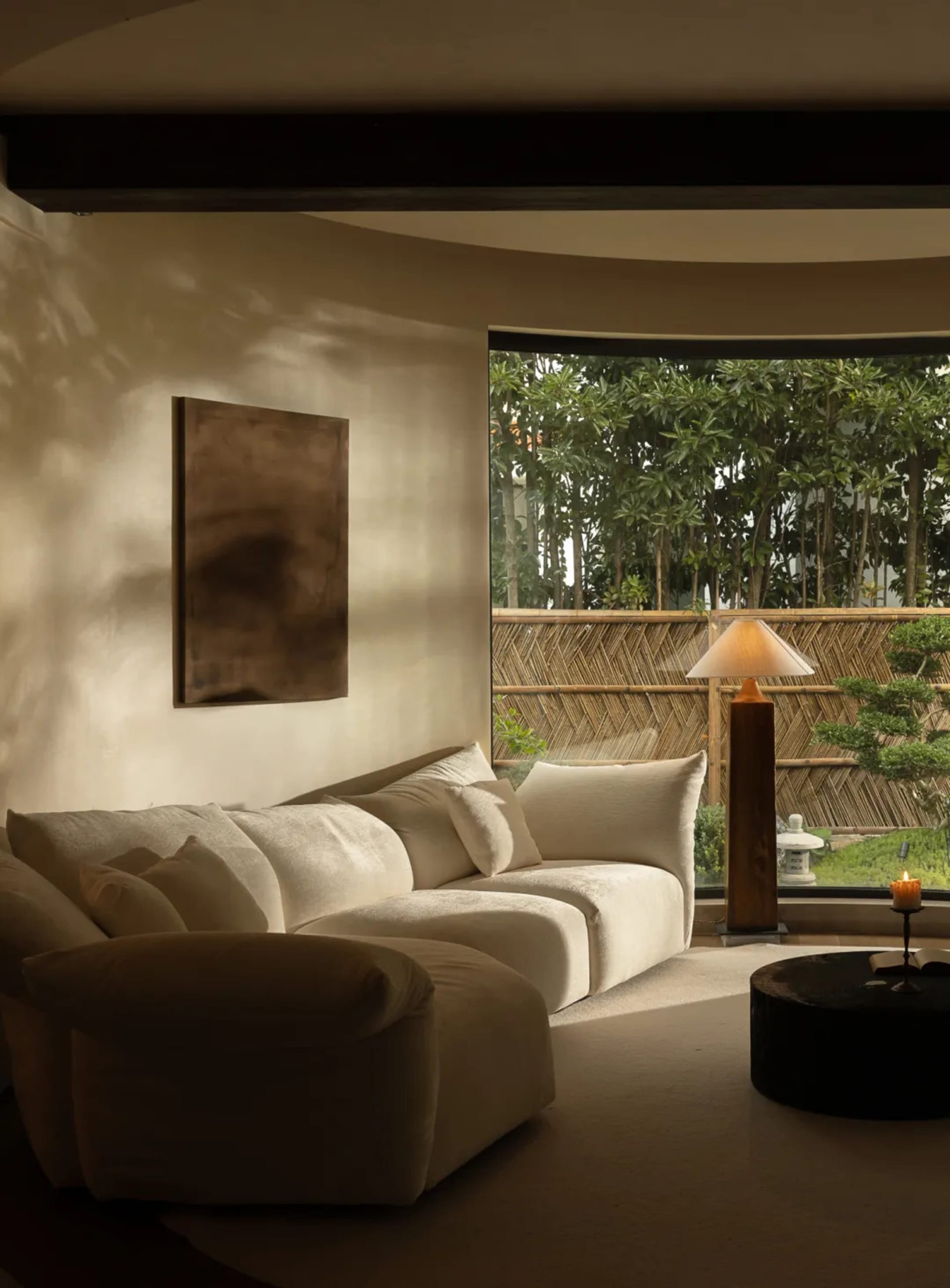 A living room with white couches and chairs arranged in front of large windows, creating a cozy and inviting atmosphere with ample natural light