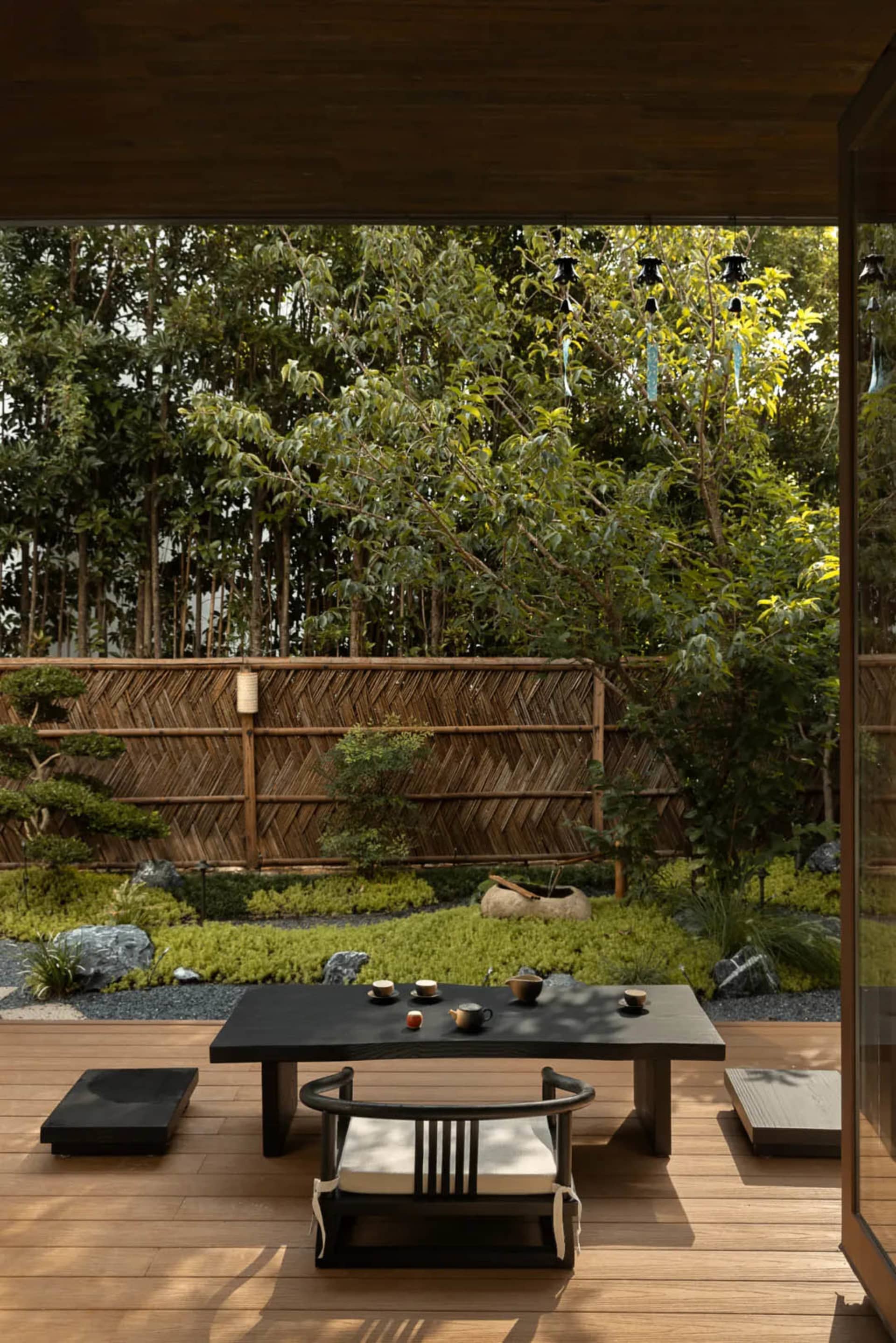 A relaxed outdoor dining space with a wooden table and metal chairs, surrounded by a patio area with a casual atmosphere