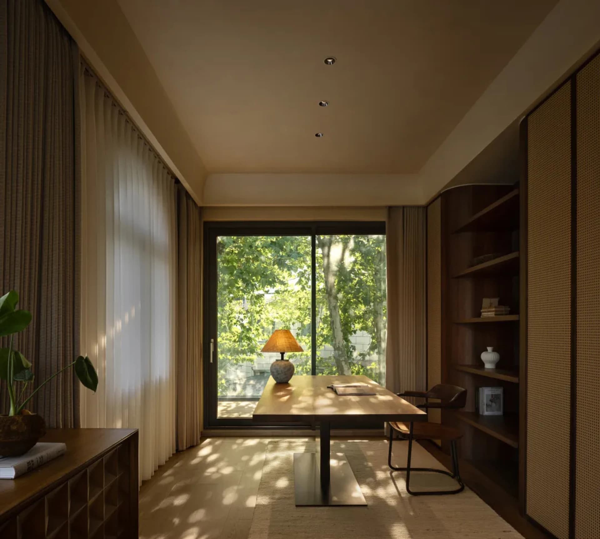 Open living area with wooden floor, neutral tones, and natural light from a large window