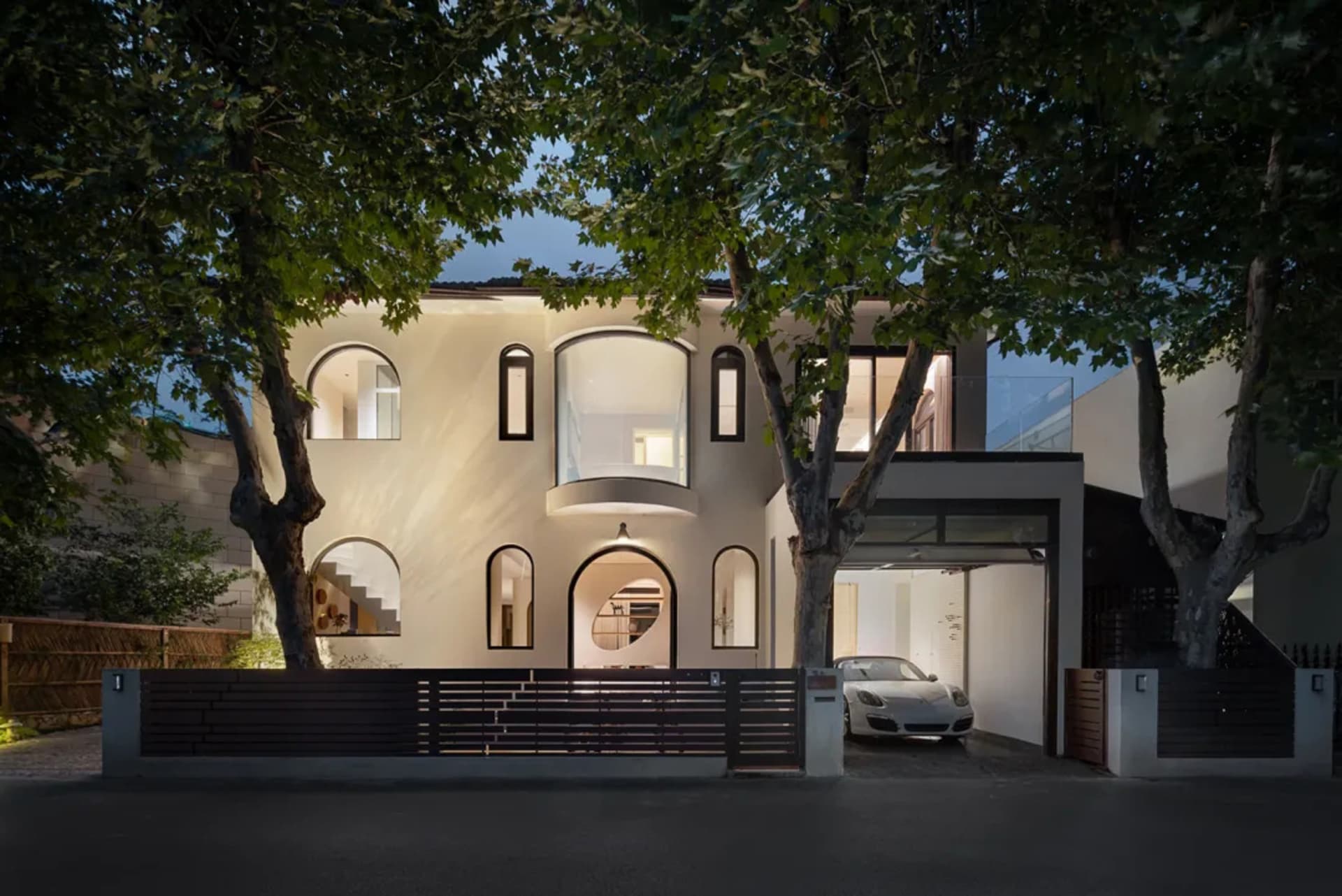 A well-lit, spacious modern home with a mix of wood and stone elements, surrounded by trees and featuring multiple windows for natural light