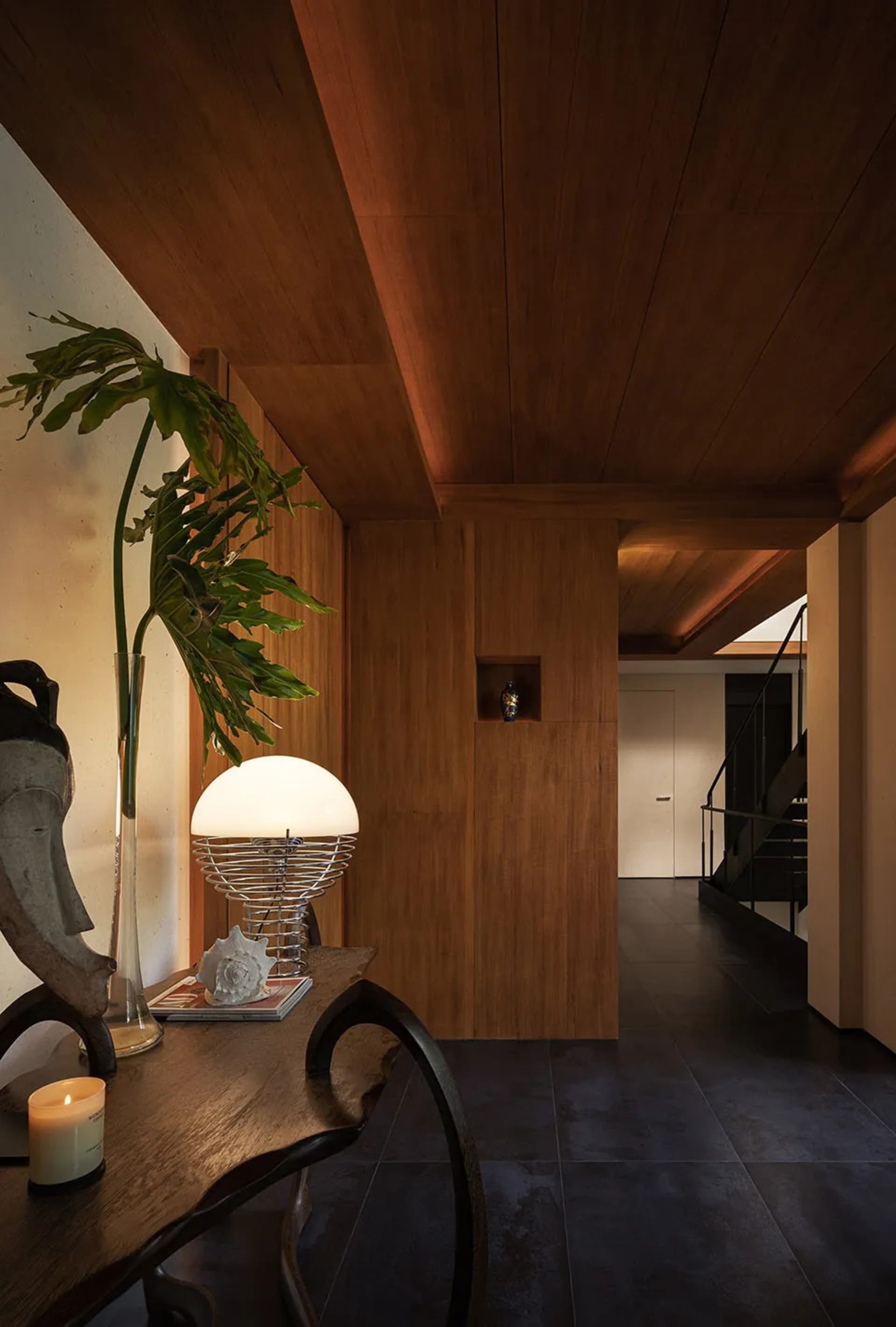 A warm and inviting dining area with a wooden table and chairs, a potted plant, and a cozy atmosphere