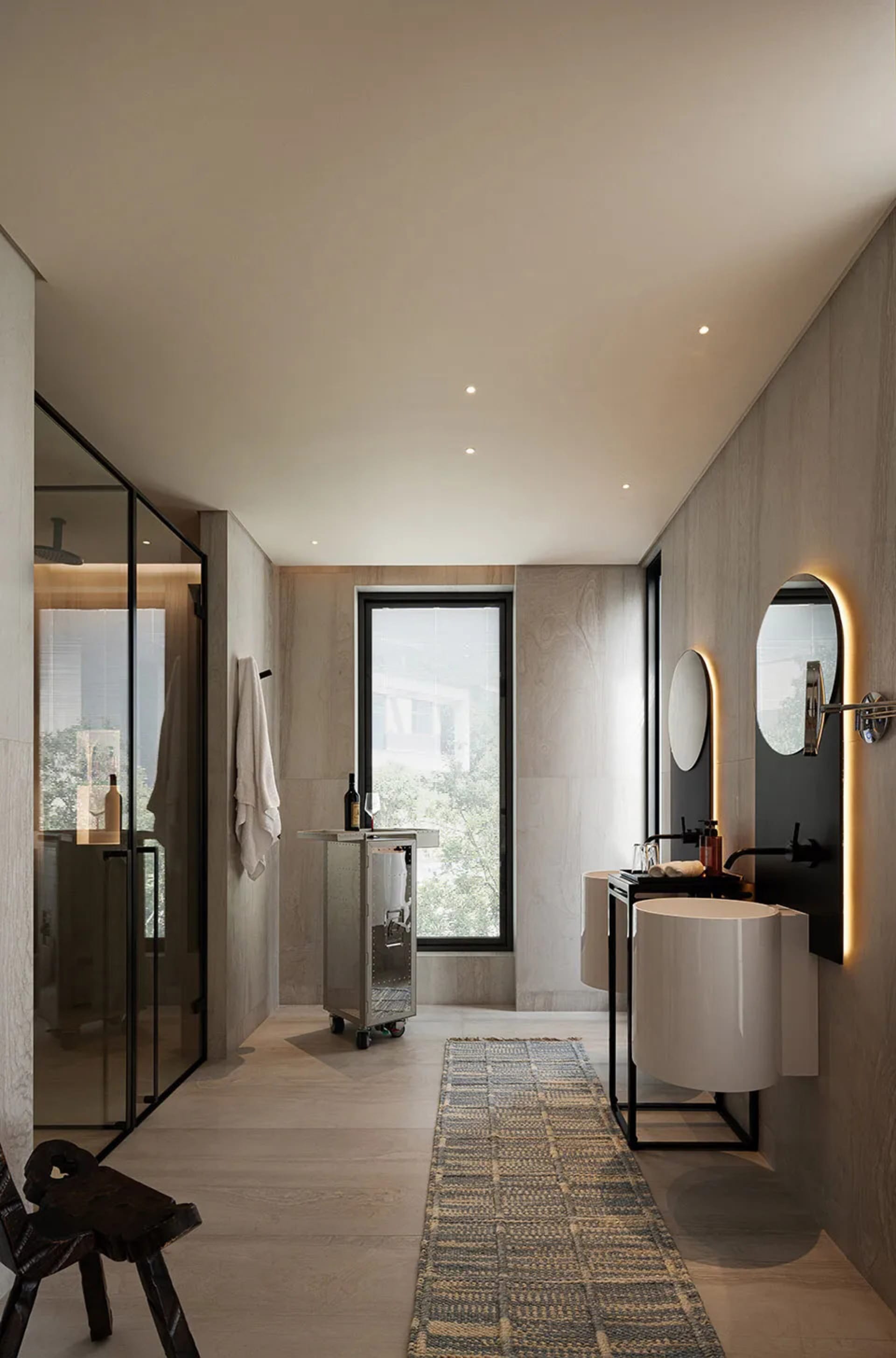 A modern bathroom with two sinks, a bathtub, and a bottle on a countertop, featuring a well-lit and inviting atmosphere