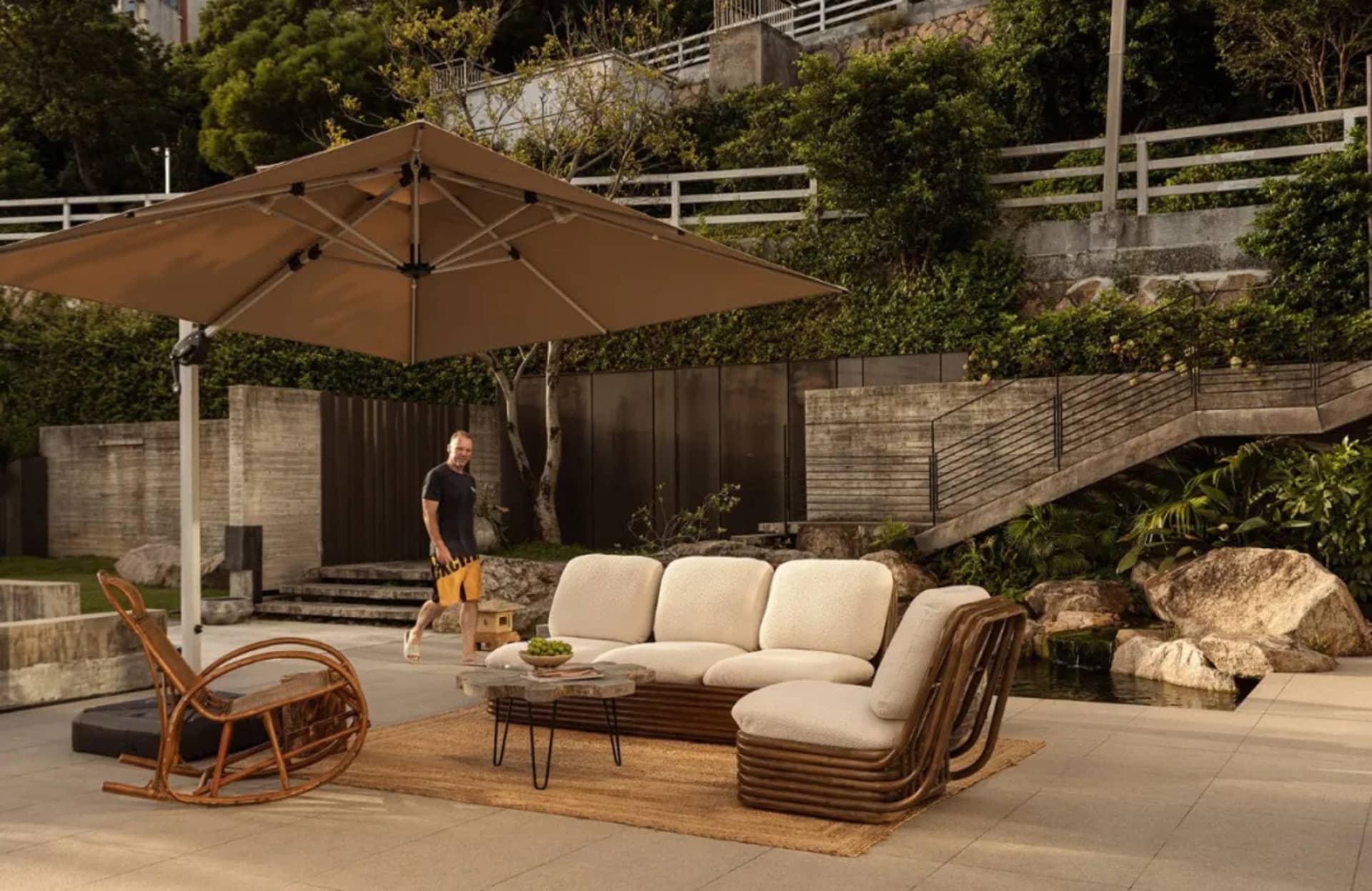 Outdoor living space with a wicker couch, chair, and dining table, surrounded by a potted plant and decorative vase