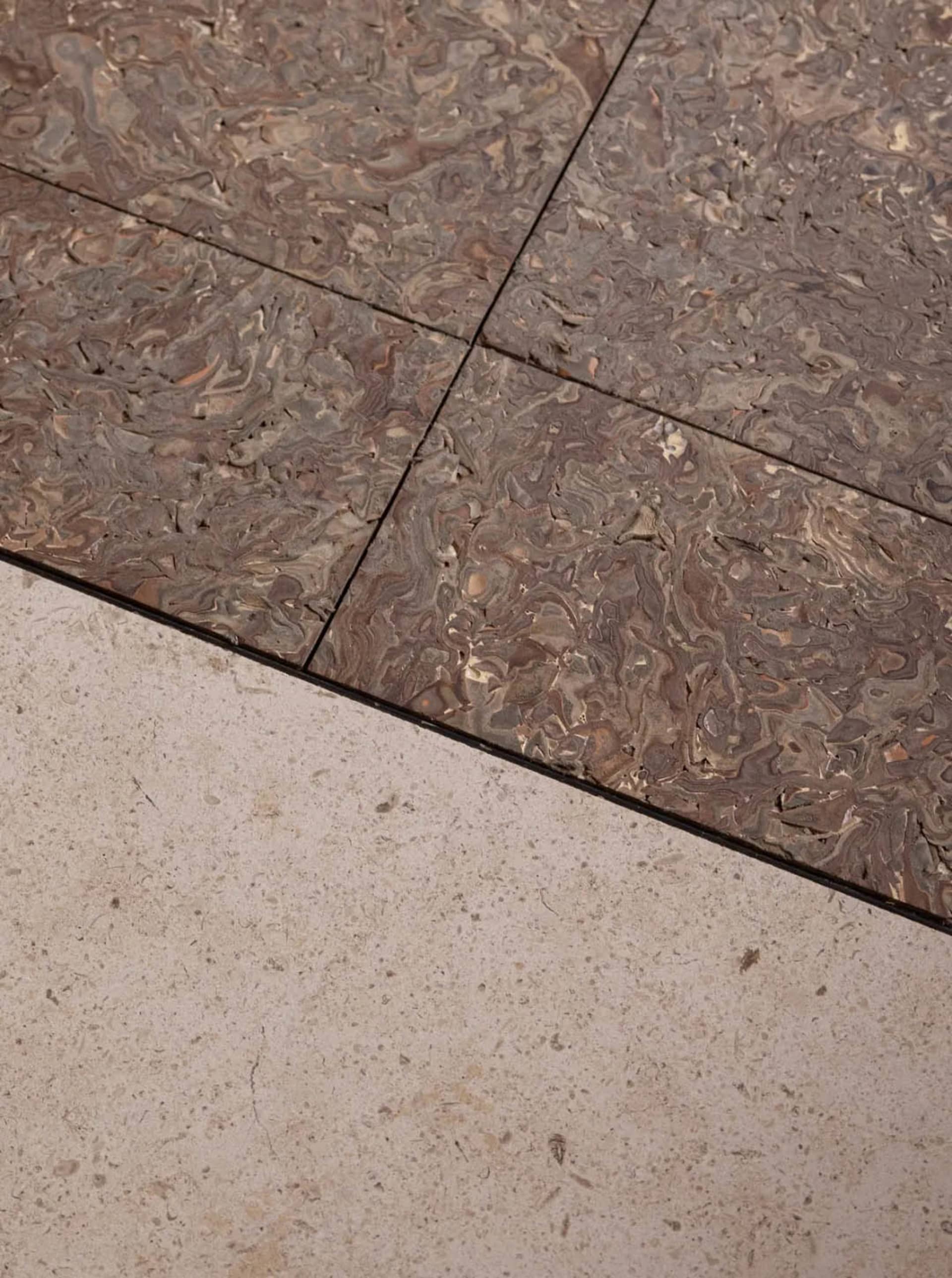 A modern living space with a tiled floor, featuring a combination of wood and stone materials, natural light, and a clean design