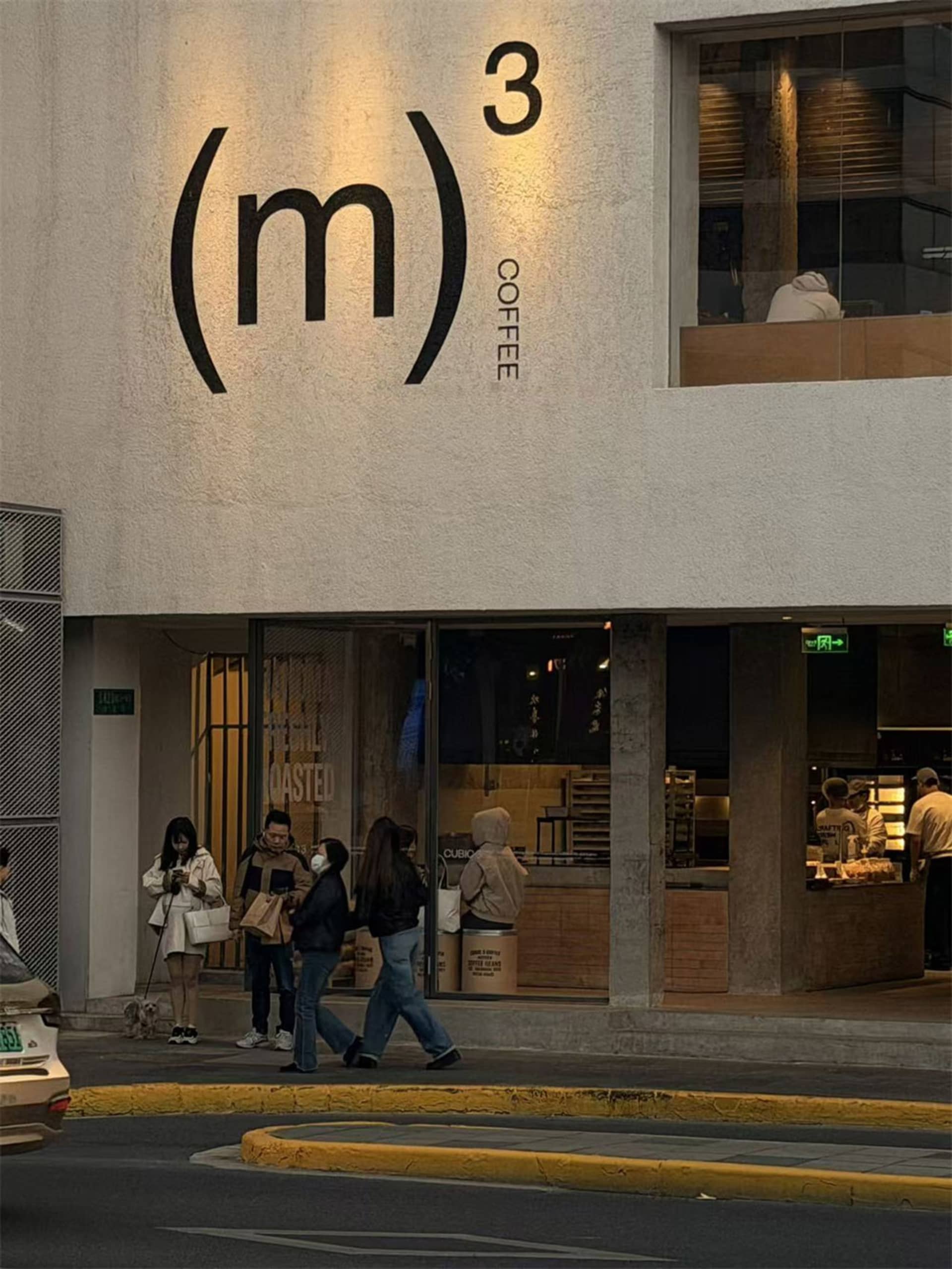 A modern coffee shop with a large window and a group of people walking outside in a city environment