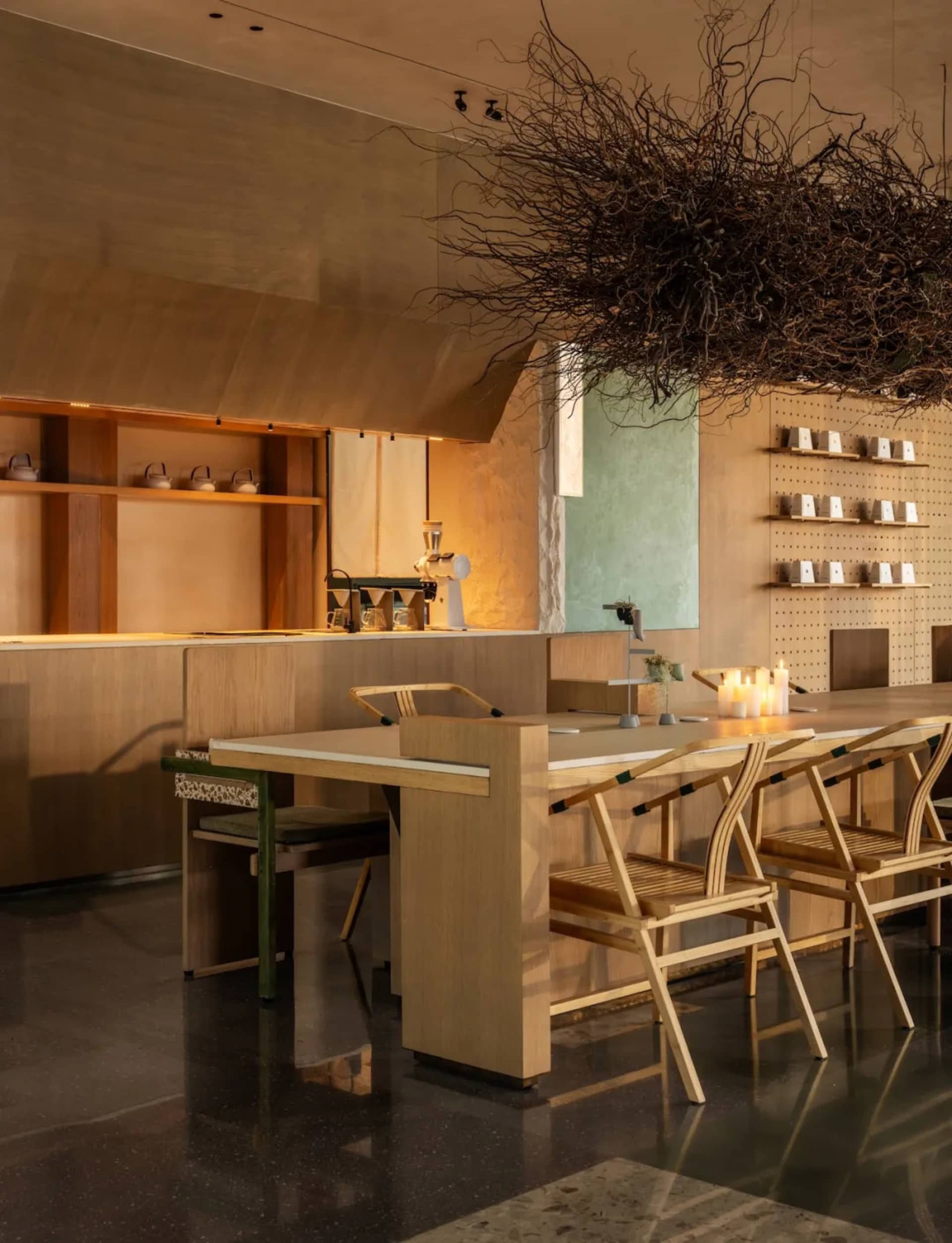 A modern kitchen with wooden floors, a wooden dining table, and a cozy atmosphere created by soft warm lighting