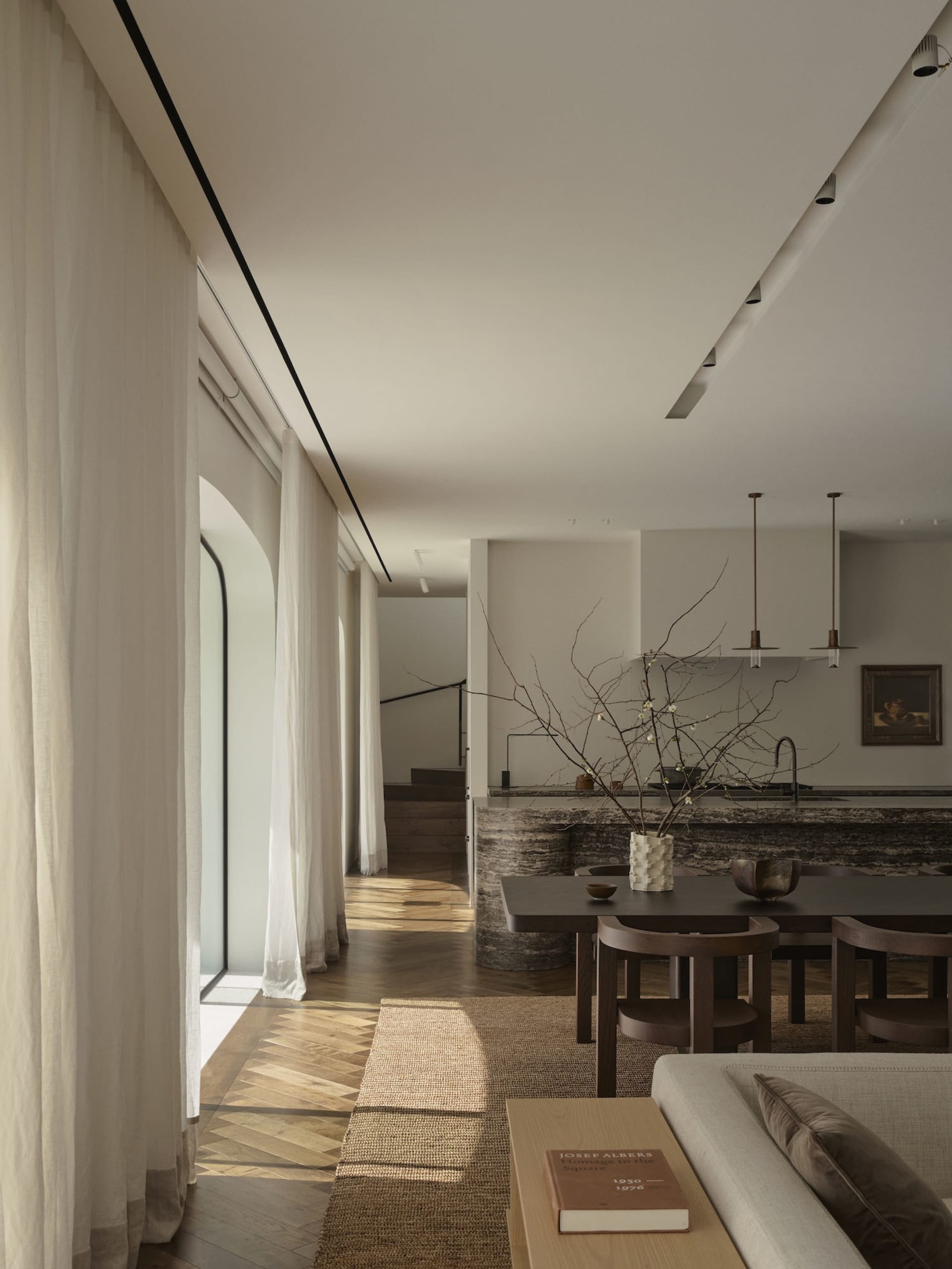 Well-lit modern kitchen with a wooden floor, stone countertop, and natural light from a window