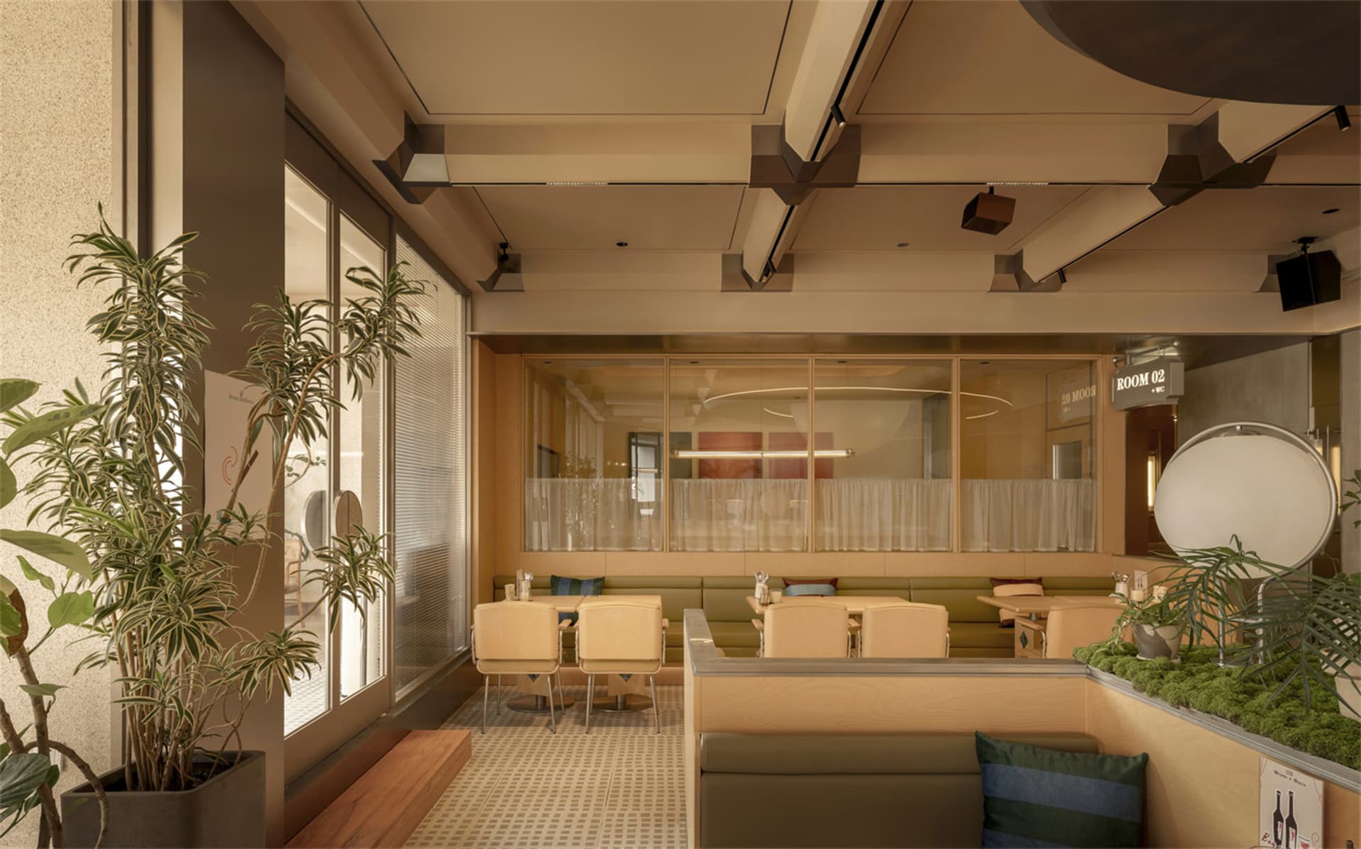 A modern restaurant with a large dining area featuring multiple tables, chairs, couches, and dining tables, well-lit with natural light and potted plants