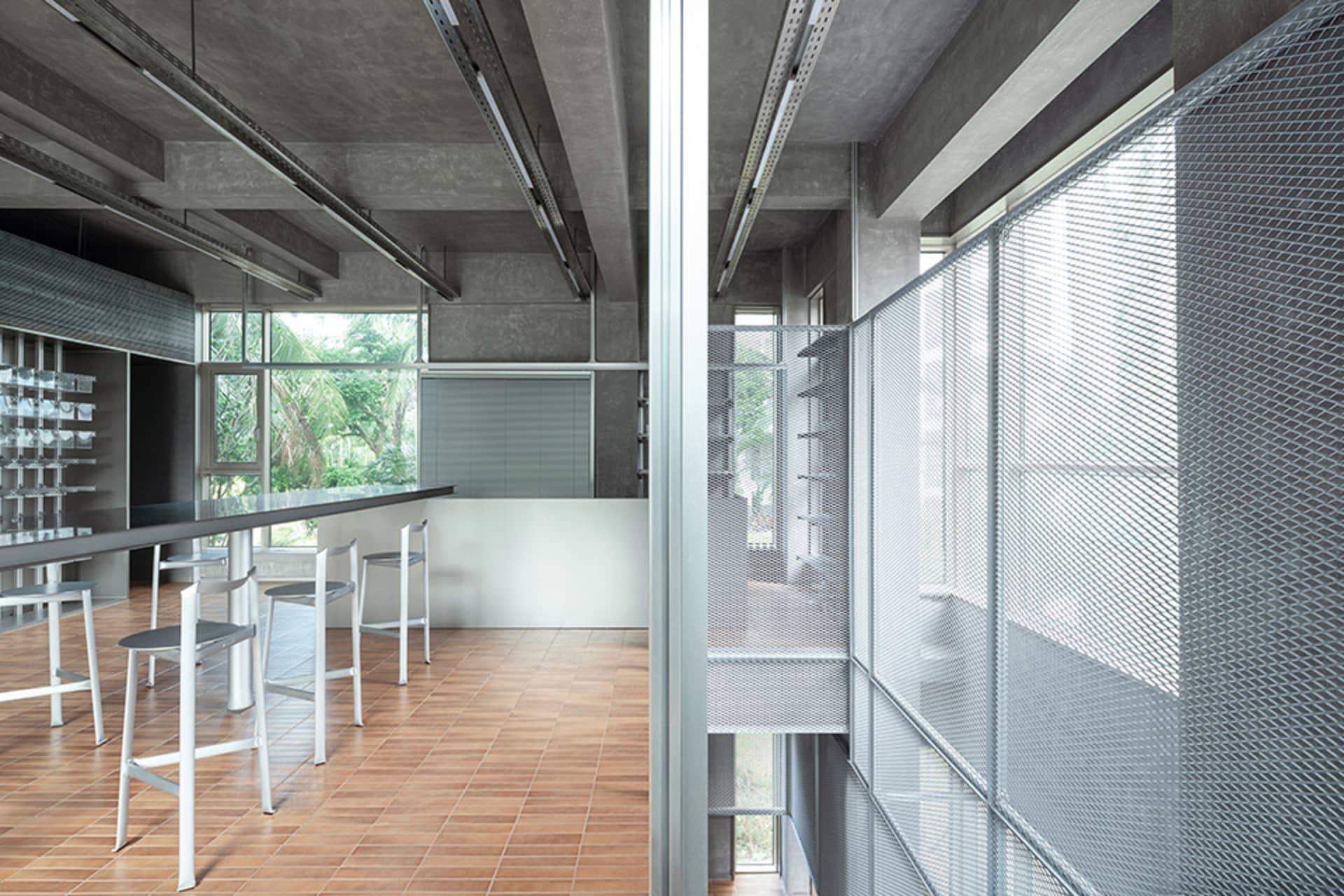 Large open room with concrete and wood elements, furniture, and natural light from windows