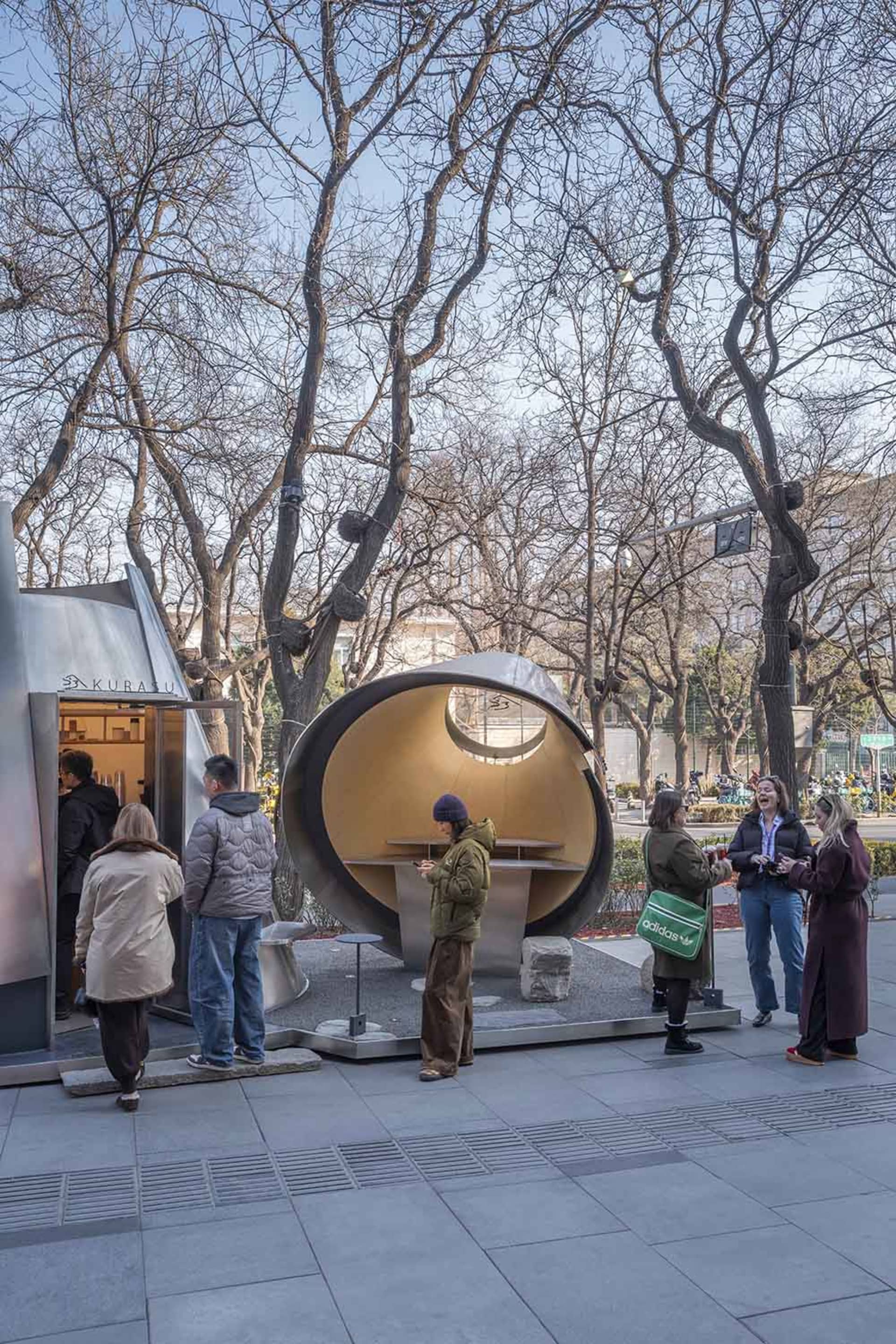 A group of people standing outside a unique dome-shaped building, creating a social atmosphere