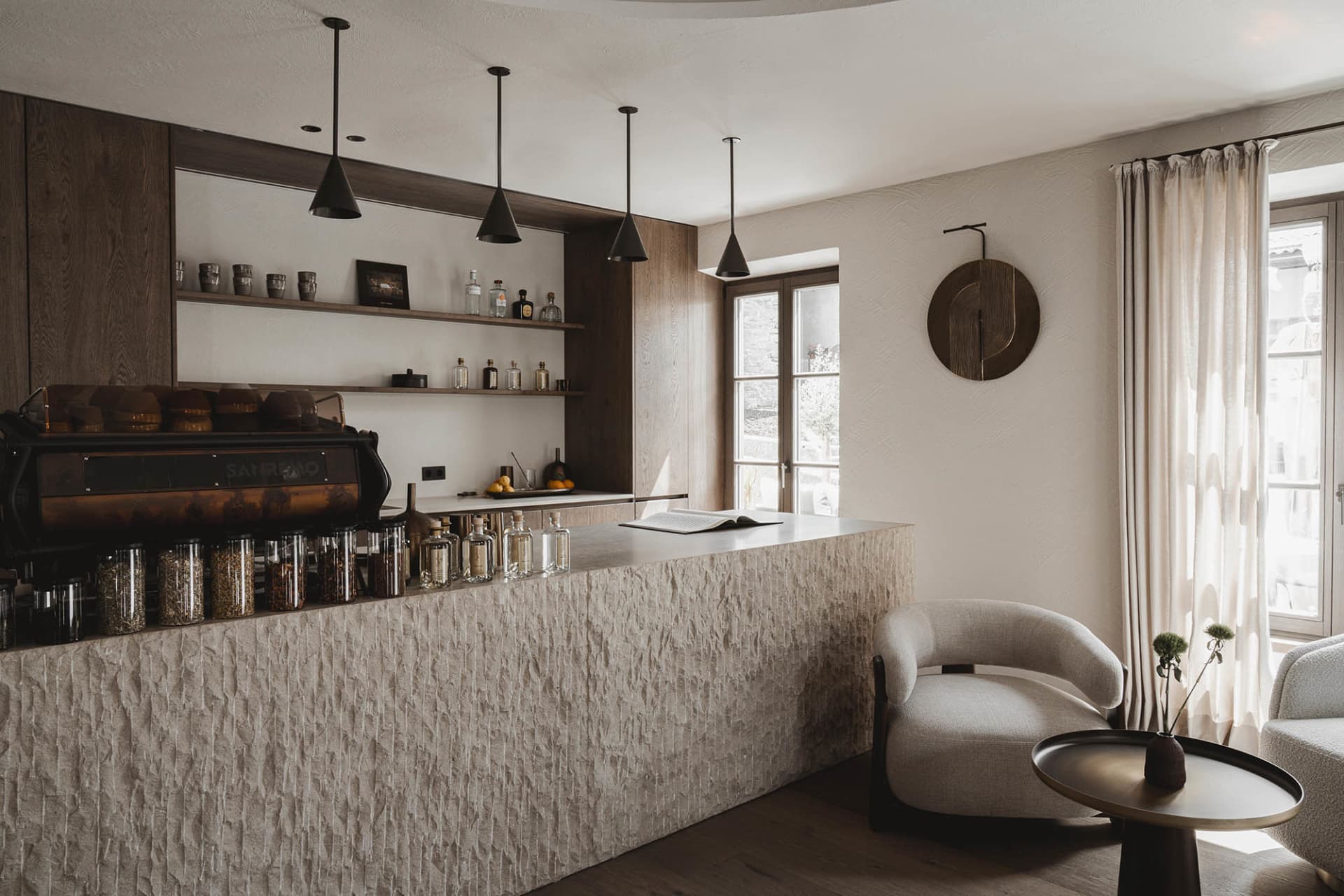 A kitchen with a marble counter, a chair, and a clock on the wall, creating a cozy and inviting atmosphere