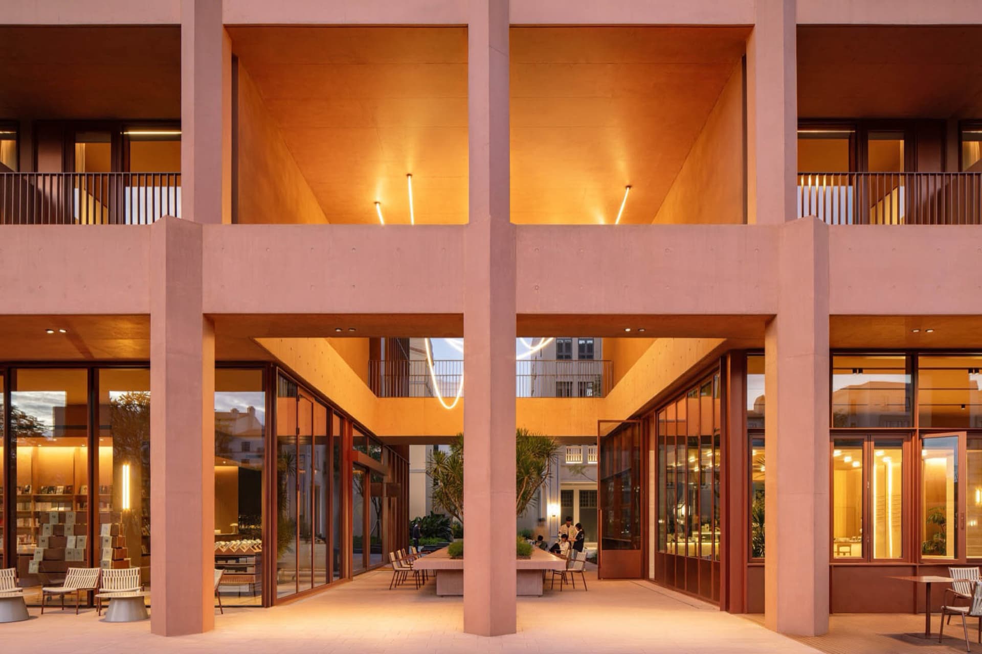 一間現代辦公空間，具有大型天井和天窗，裝飾著家具和自然光線
