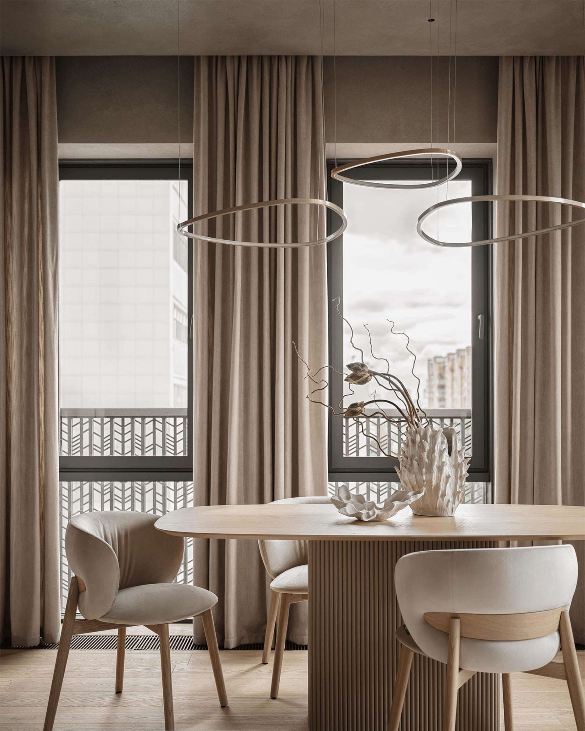 A well-lit living room with a dining table, chairs, and a vase, featuring a mix of wood and glass materials in a modern and inviting space