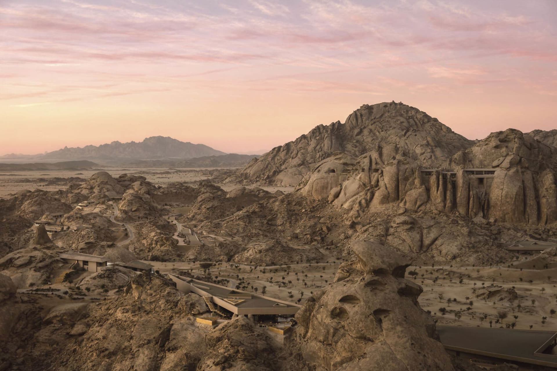 A serene natural landscape with a rocky terrain and a large rock formation, captured during sunset