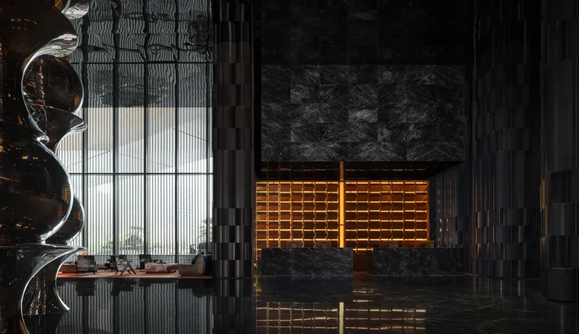 Black and white lobby with a large window, a chair, a couch, and a potted plant, featuring a classic and timeless design