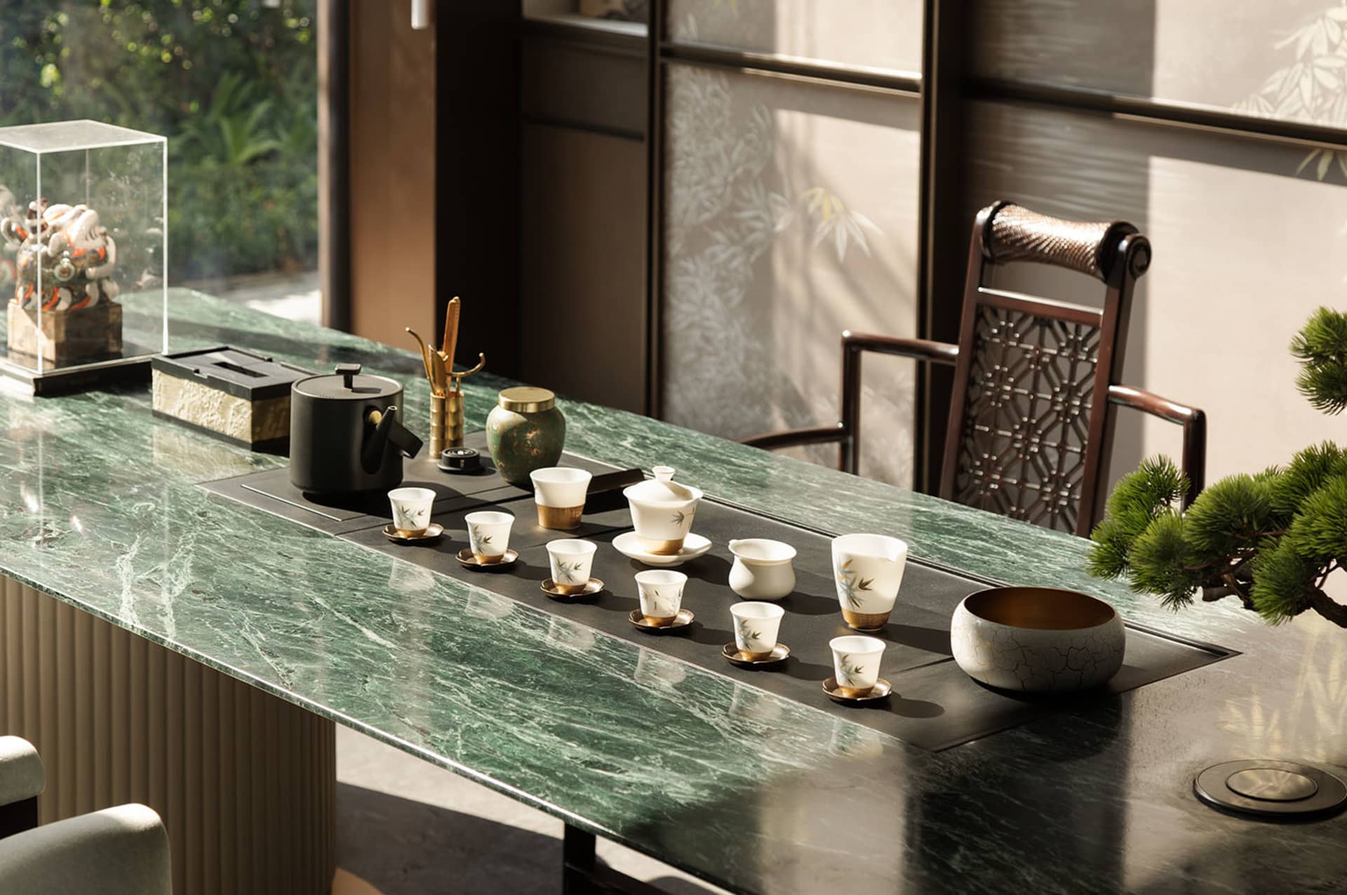A well-lit dining room with a marble table, chairs, and decorative cups and bowls
