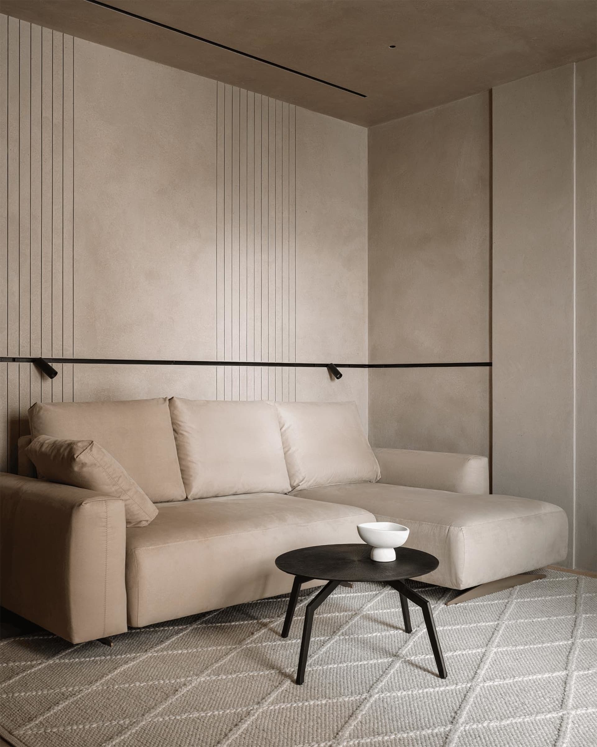 Cozy living room with a brown sofa, a black coffee table, and a white bowl, set in a dimly lit space