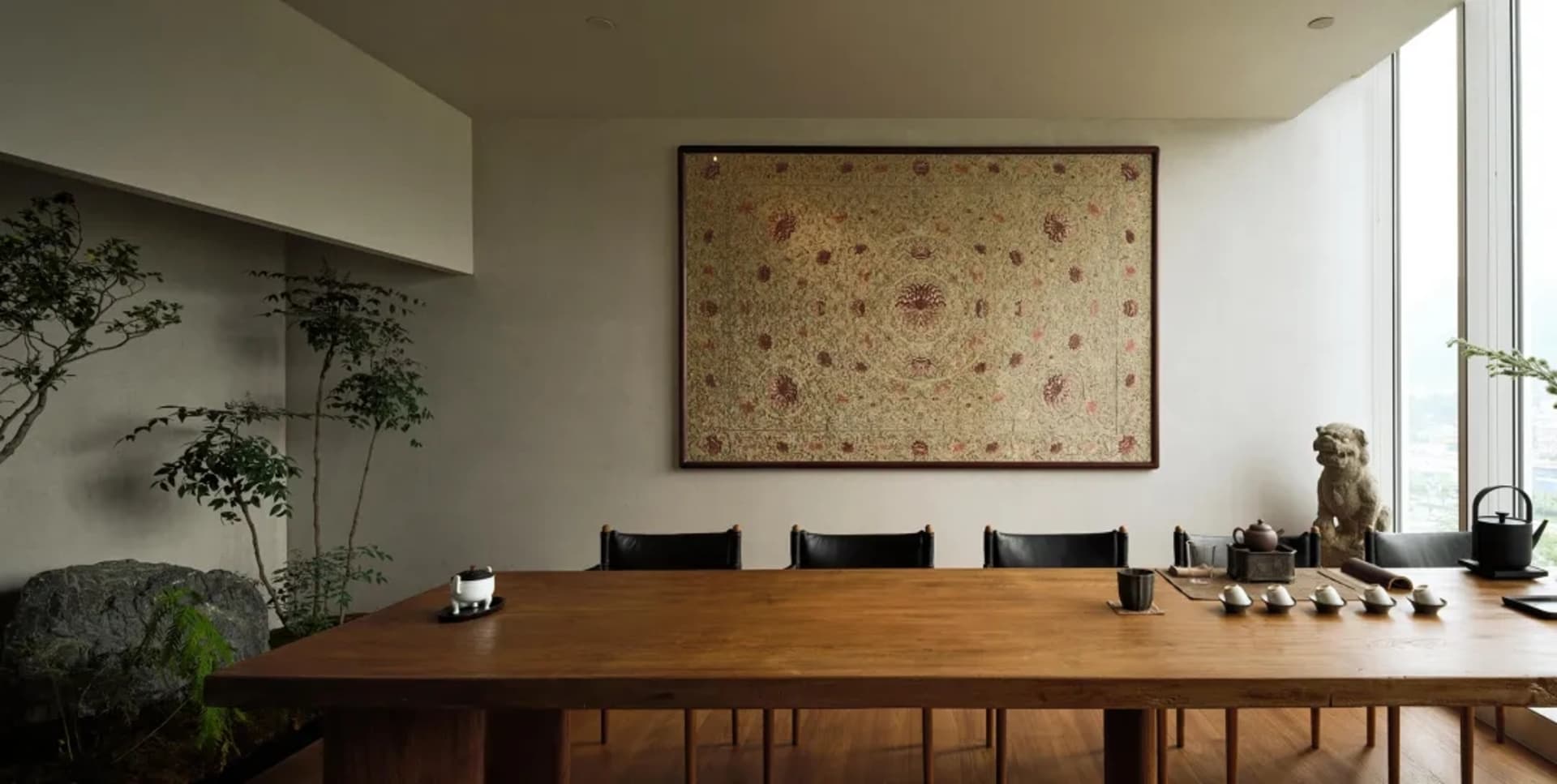Warm and inviting dining space with a wooden table and chairs, a large rug, and a setting for a meal