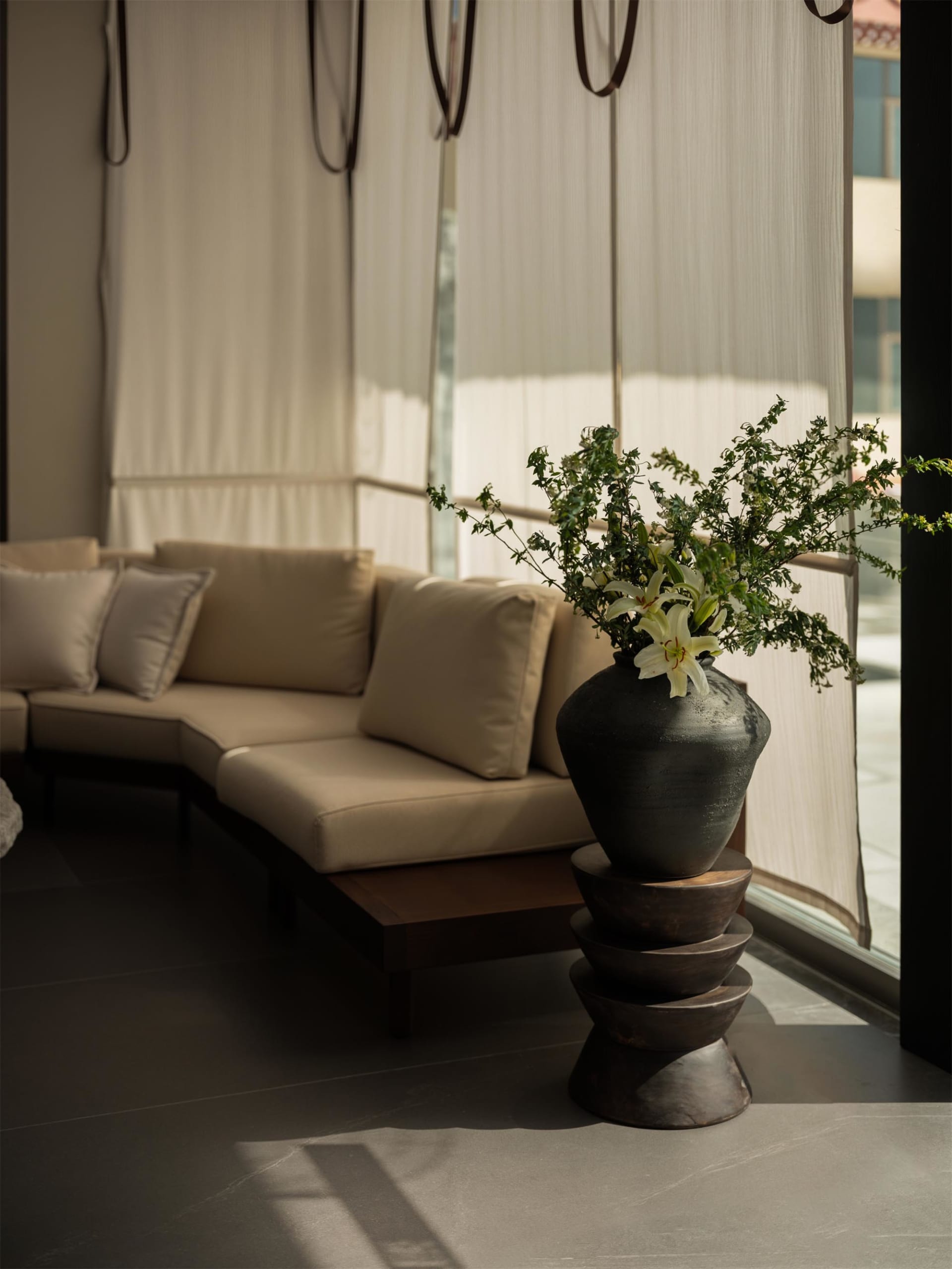 A well-lit living room with a couch and a vase with flowers on a table, creating a comfortable and inviting atmosphere