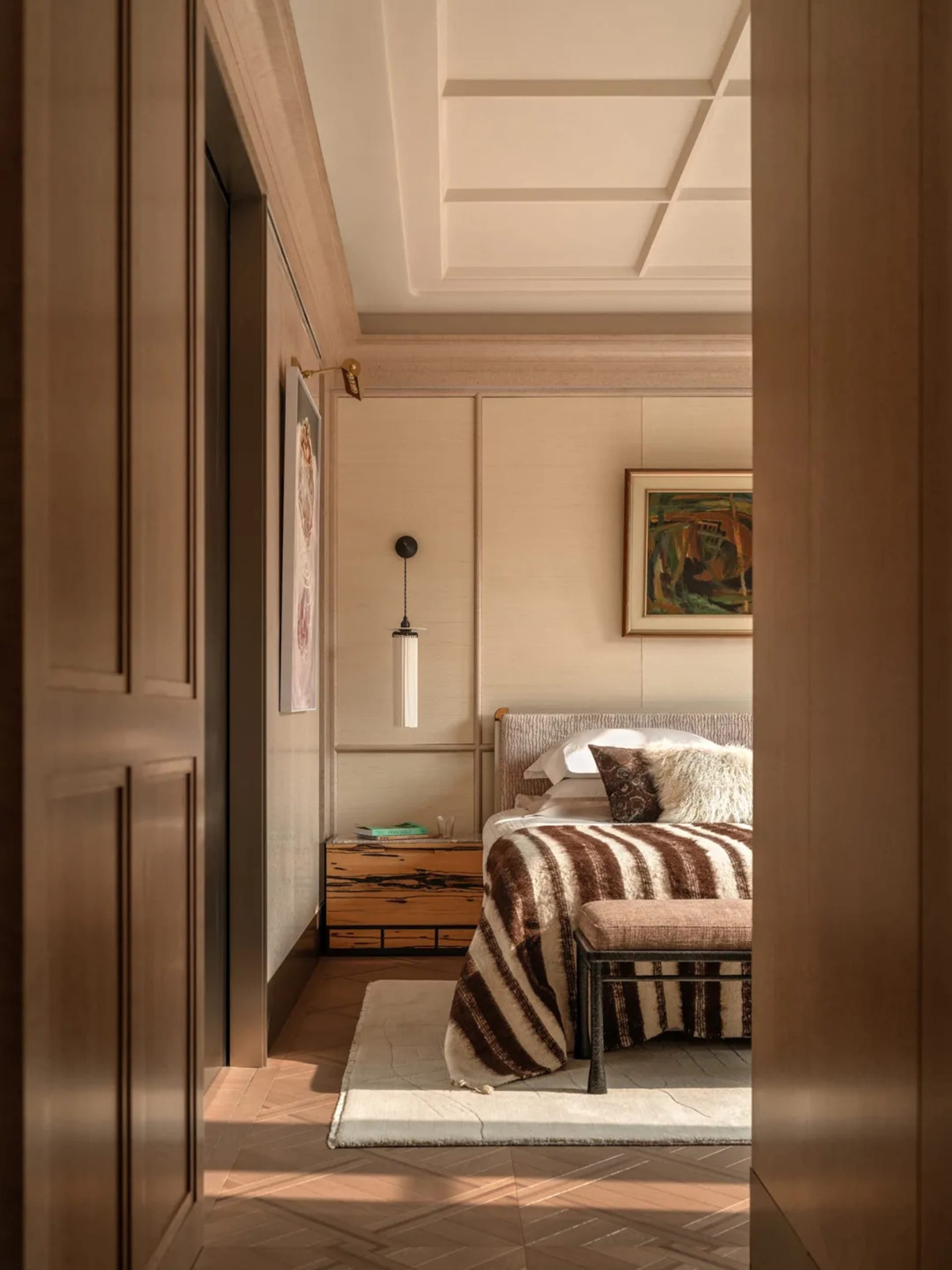 Wooden bedroom with a bed, chair, and couch, warm and cozy atmosphere, natural lighting