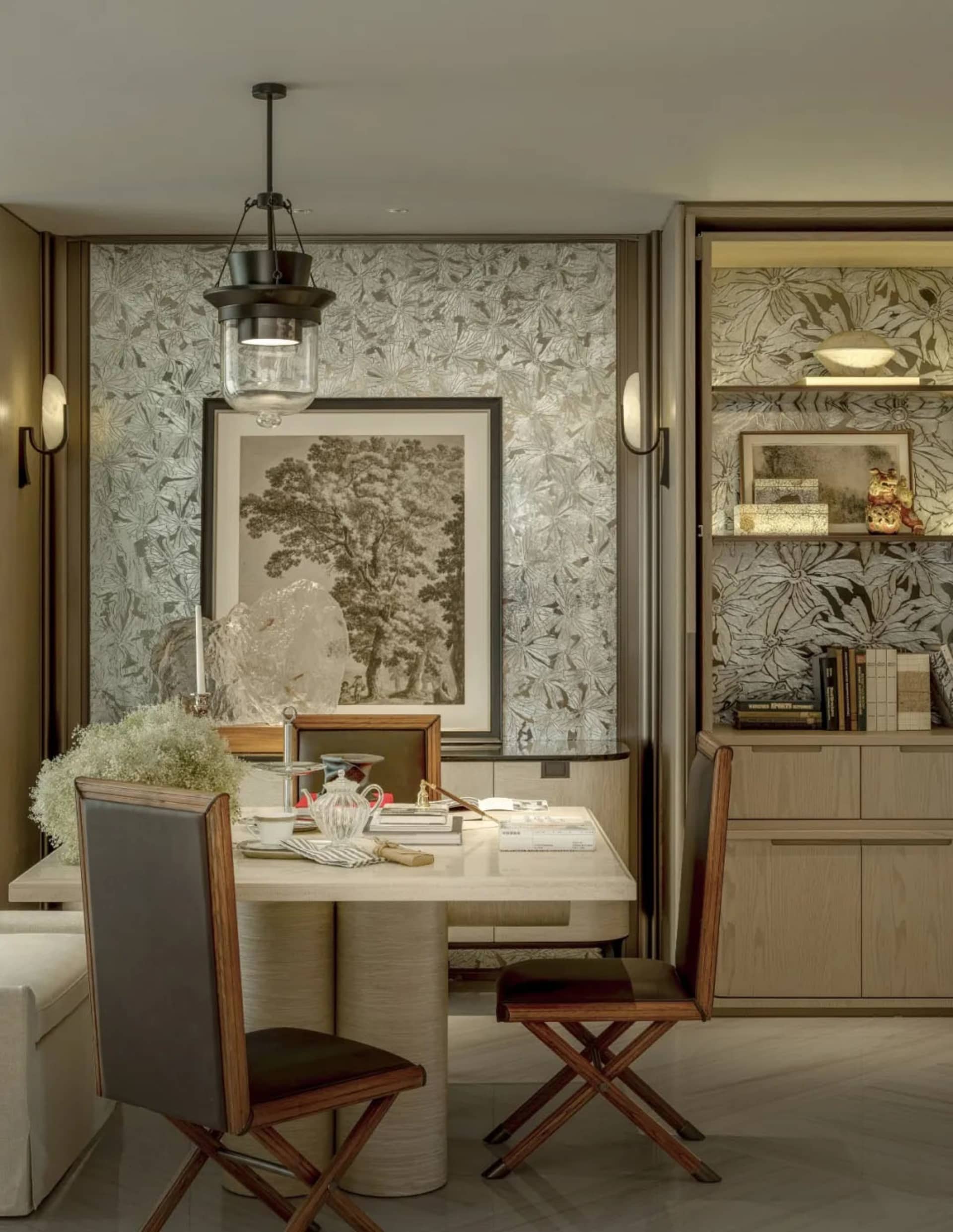 A warm and inviting living room with a dining table, chairs, couch, bookshelf, vase, and potted plant, surrounded by wood and metal materials, illuminated by natural light
