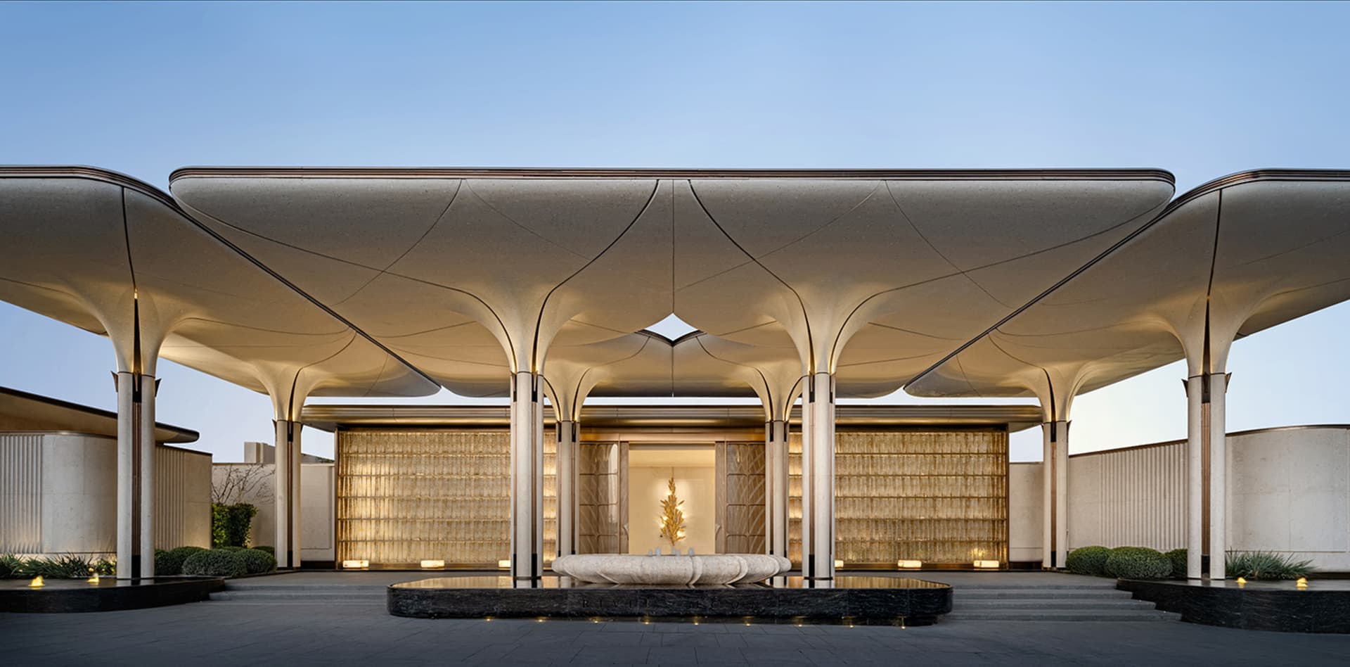 Large, open lobby with a curved wall, natural light from a large window, and a luxurious atmosphere