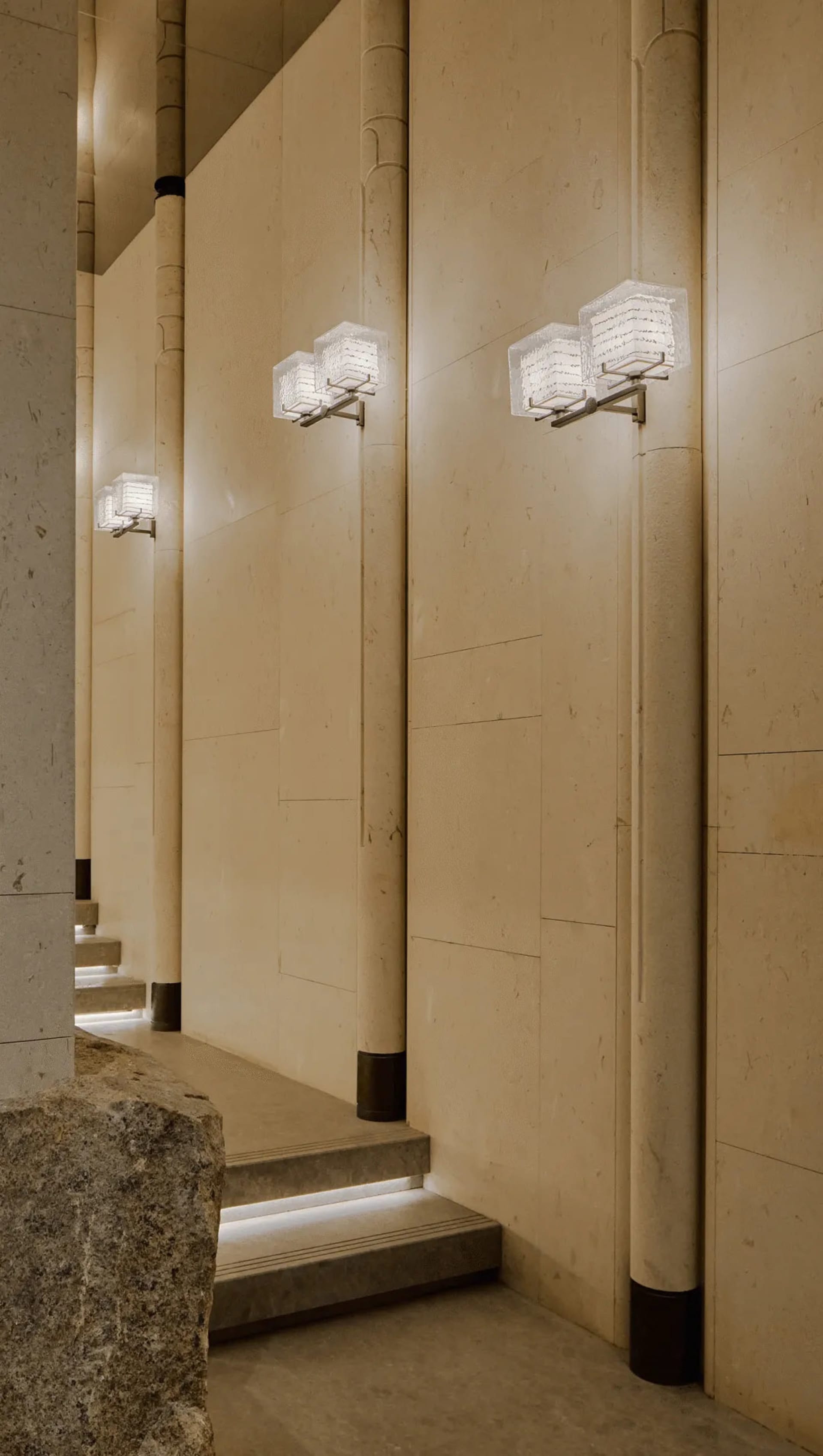 A well-lit hallway with a row of wall-mounted lights, set against a concrete background, creating a functional and practical atmosphere