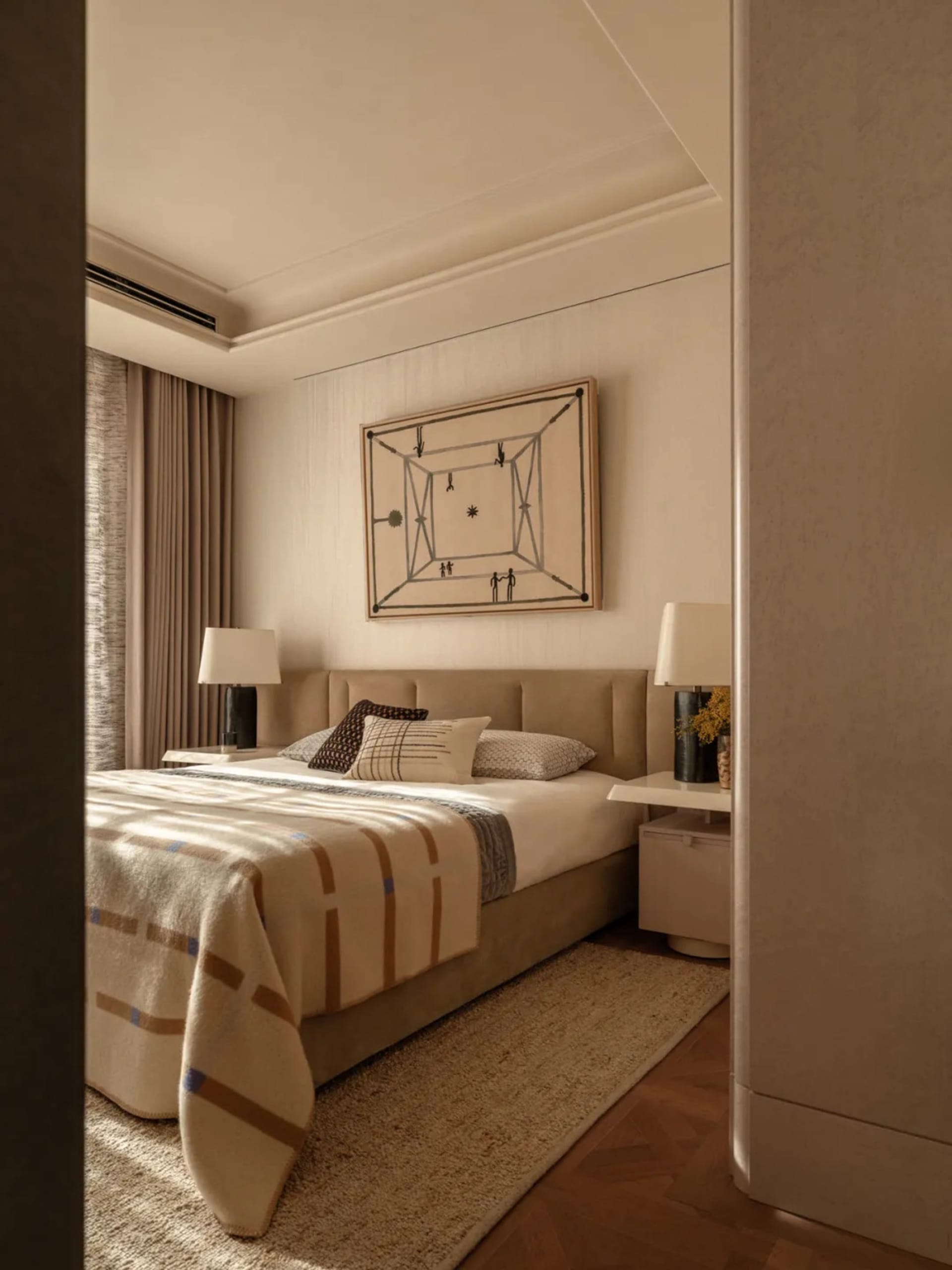 A well-lit bedroom with a bed, nightstand, and painting, featuring warm wood and fabric materials