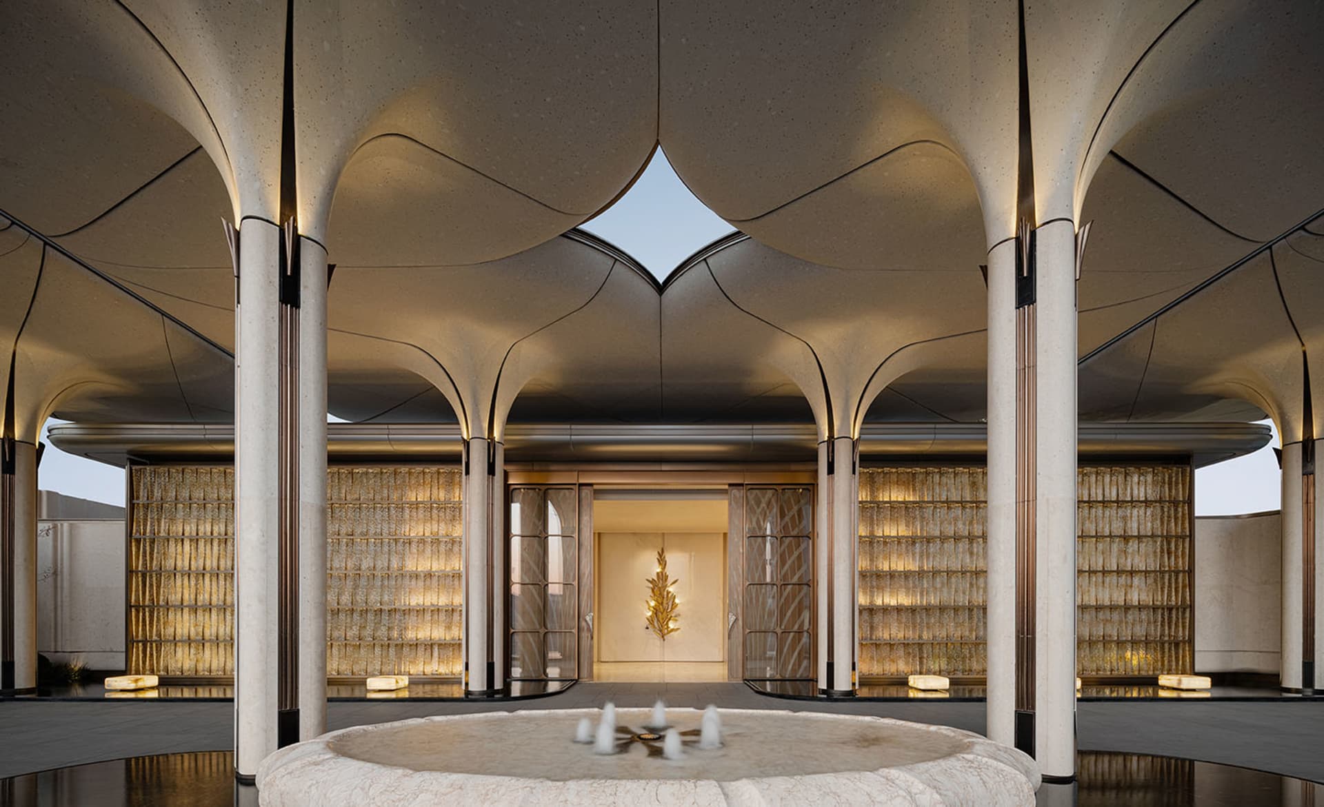 A modern lobby with a circular pool, white surfaces, and natural light from windows, featuring comfortable seating and a clean design
