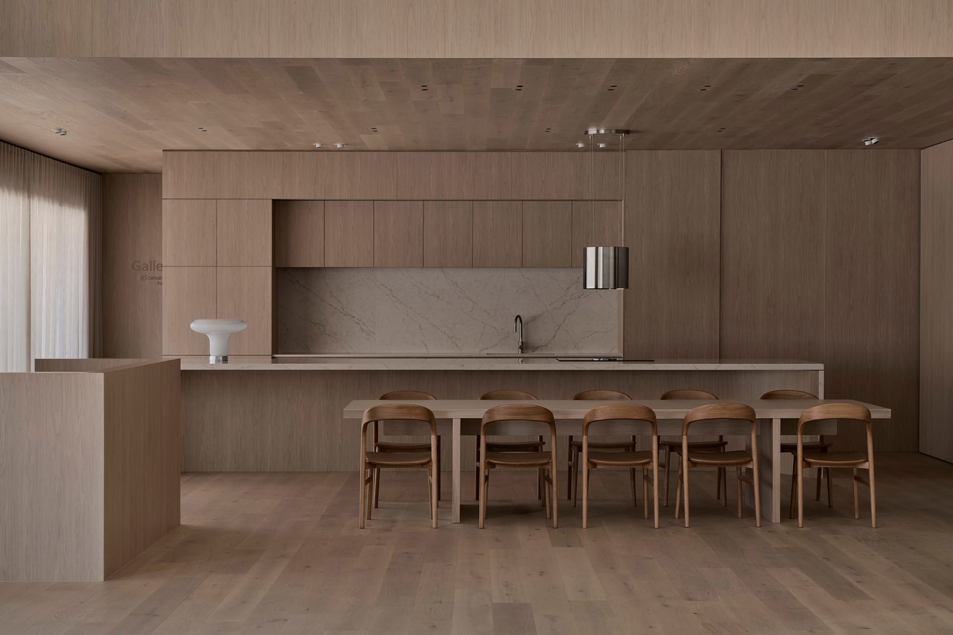 Modern kitchen with wooden floors and cabinets, featuring a sink, refrigerator, dining table, and chairs, with a vase on the table, under soft and warm lighting