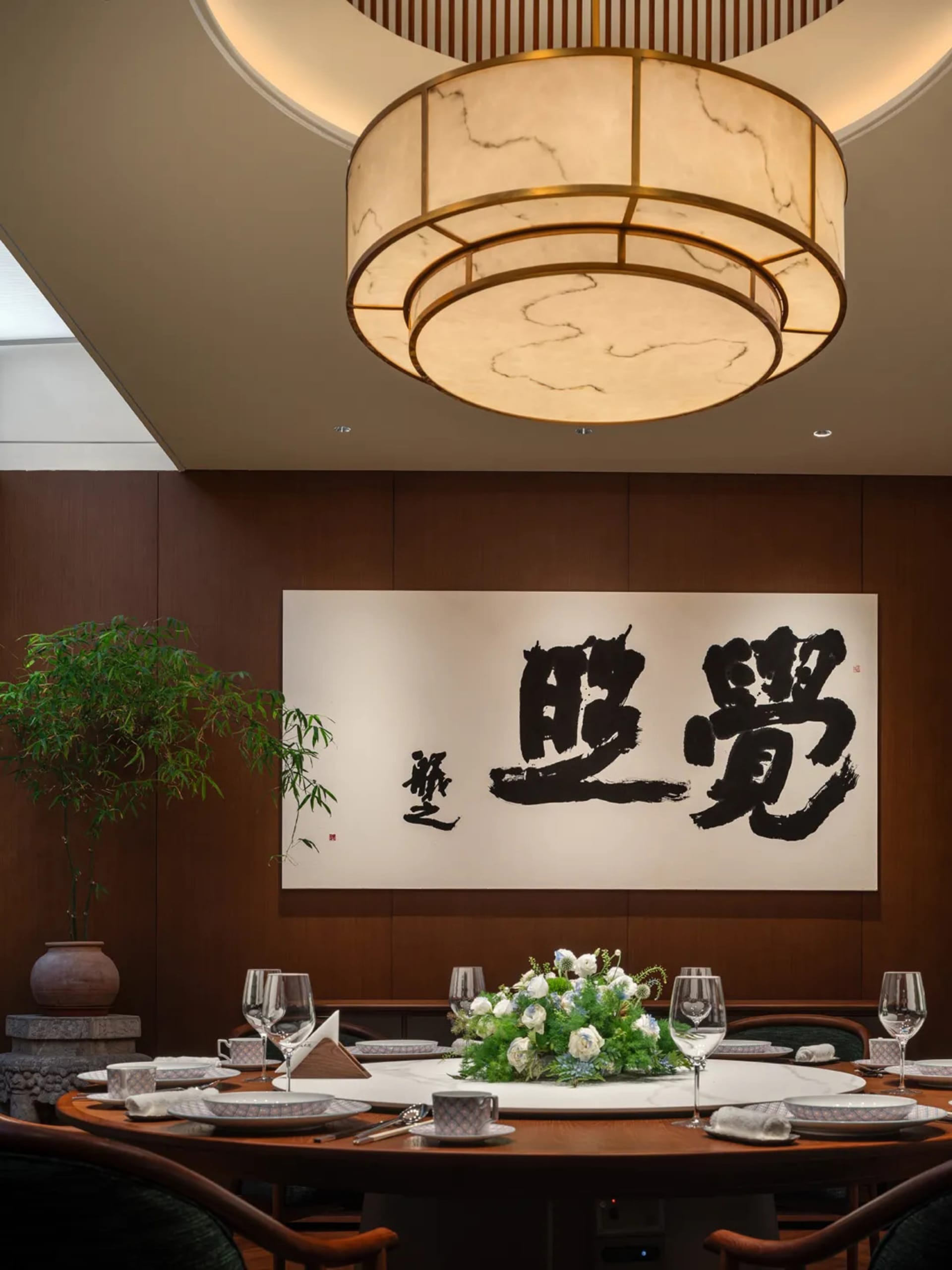 餐廳內有木地板、擺放著酒杯和杯子、花瓶,吊燈掛在天花板上