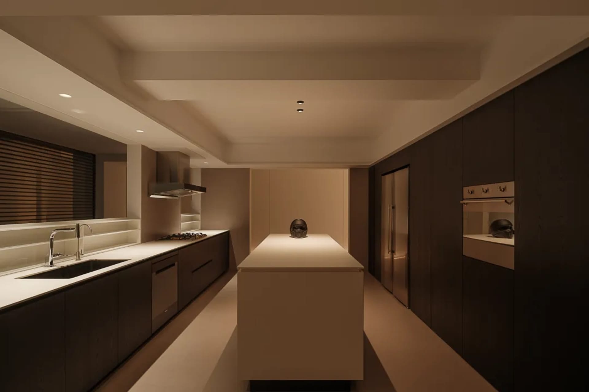 Modern kitchen with a white countertop, black appliances, and a dimly lit atmosphere, featuring a skull decoration