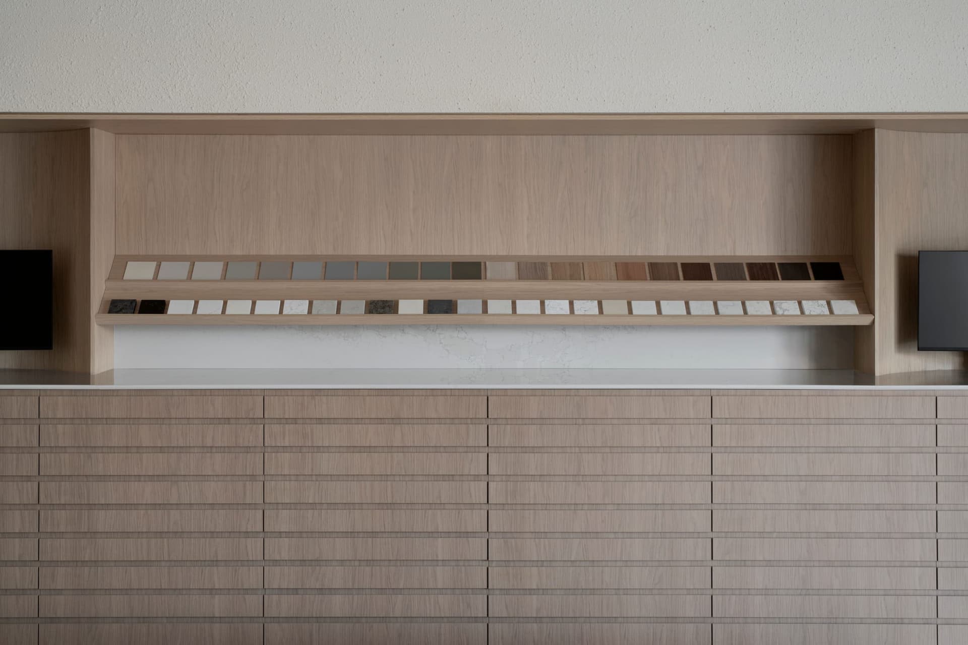 A modern kitchen with a wood cabinet, patterned tiles, and open drawers, featuring a functional and organized design