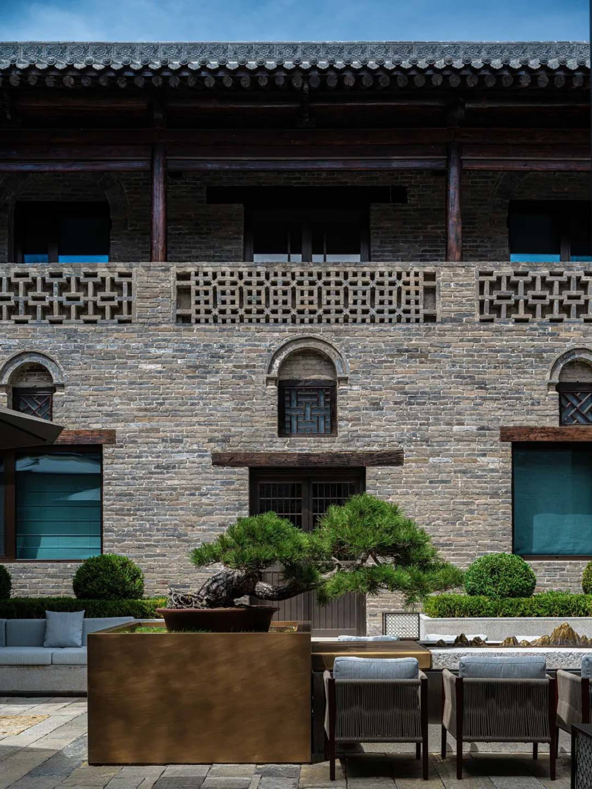 A stone building with a brick facade, adorned with windows, set against a city backdrop