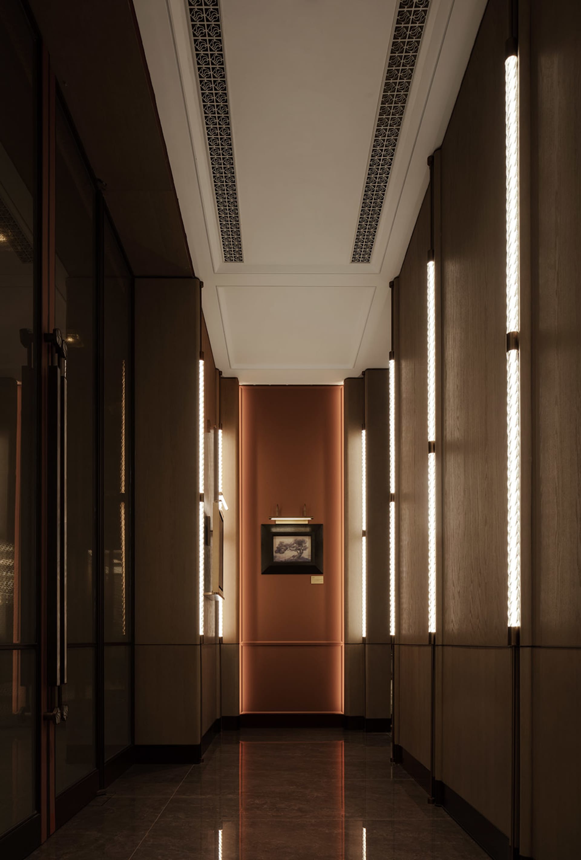 A dimly lit hallway with wooden walls, a brown color scheme, and a painting on the wall adds an artistic touch