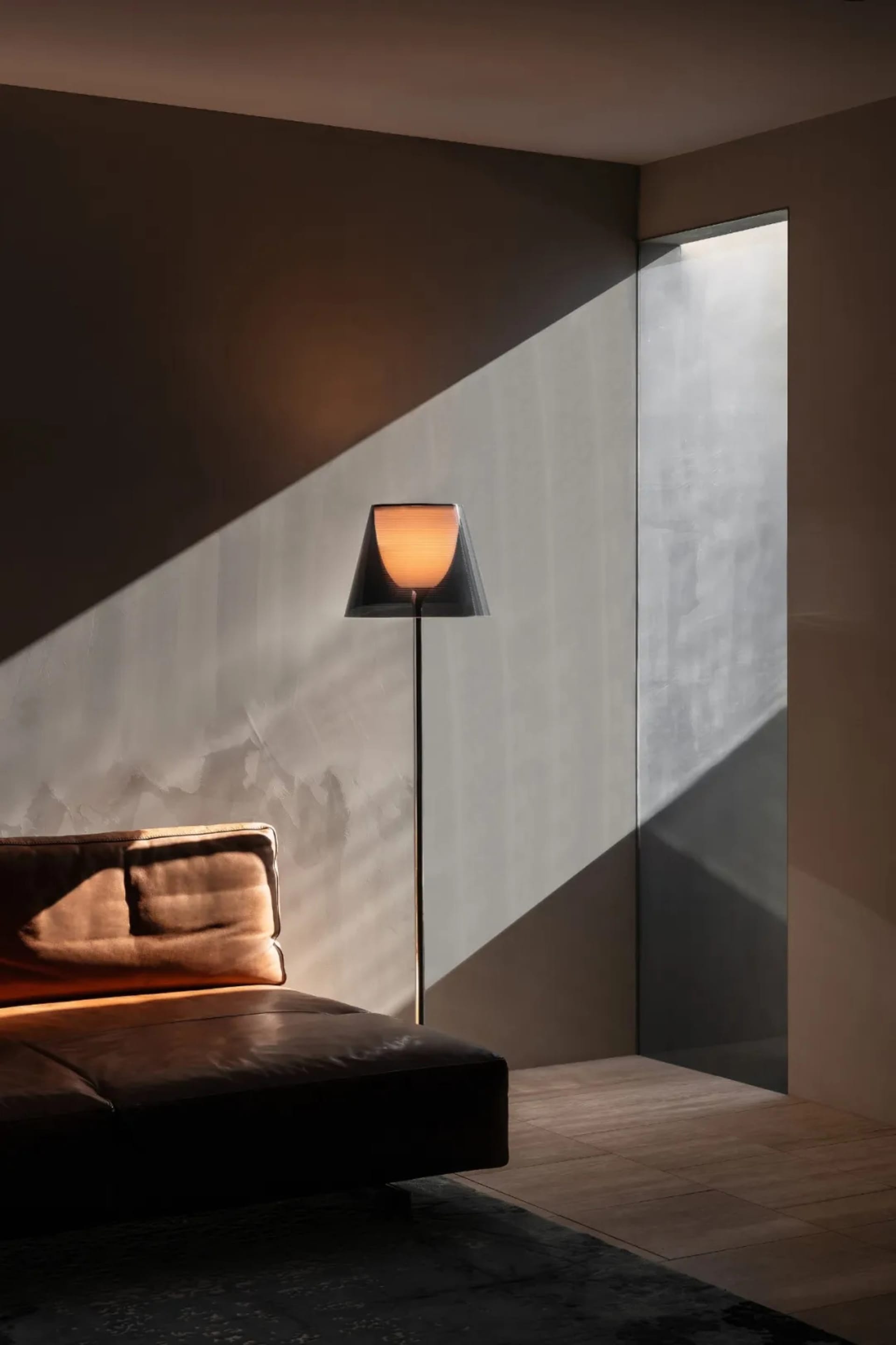Cozy living room with a leather sofa, a table, and a lamp, dimly lit for a warm atmosphere