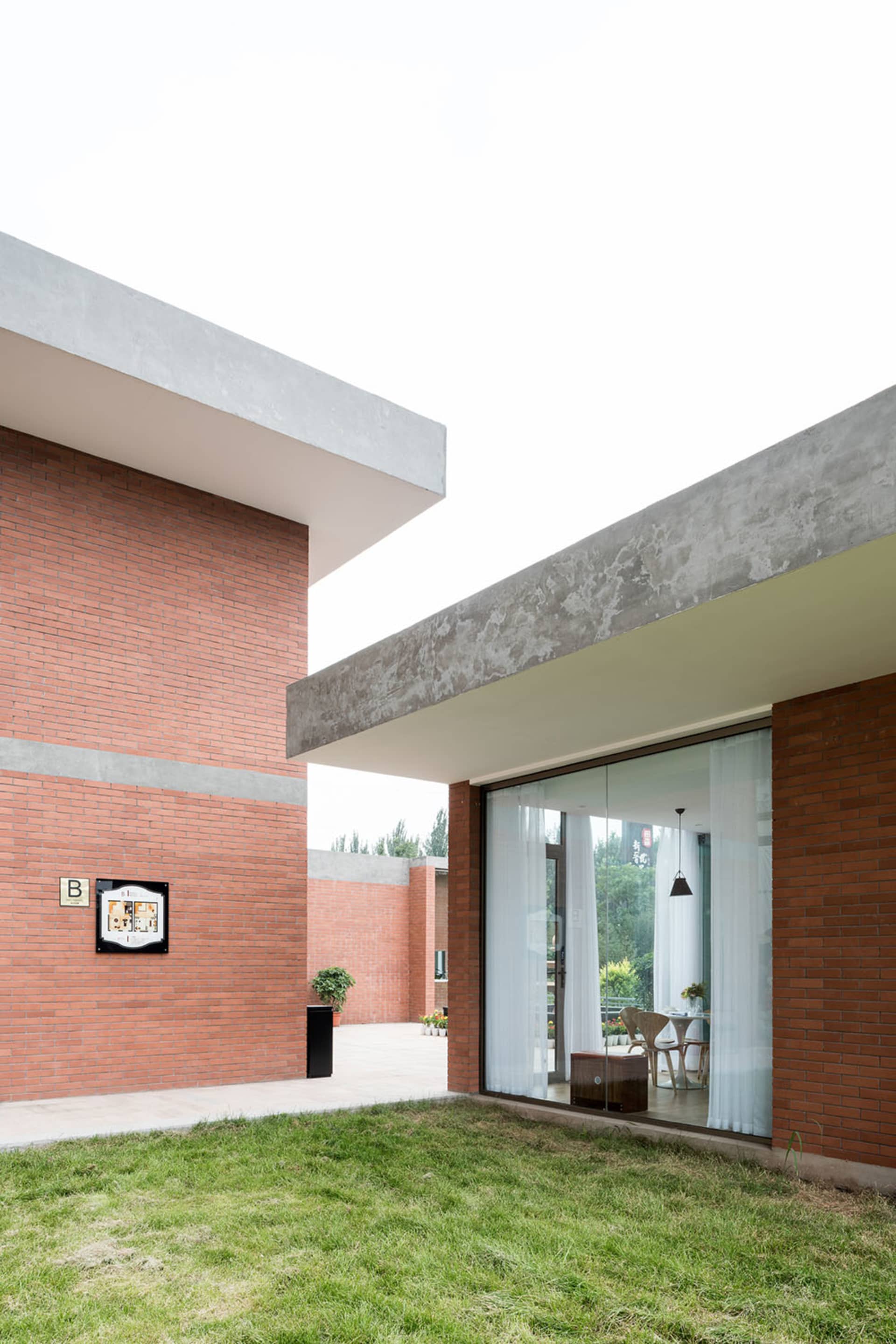 A modern brick building with a glass door and window, featuring a contemporary design with clean lines and minimalistic elements