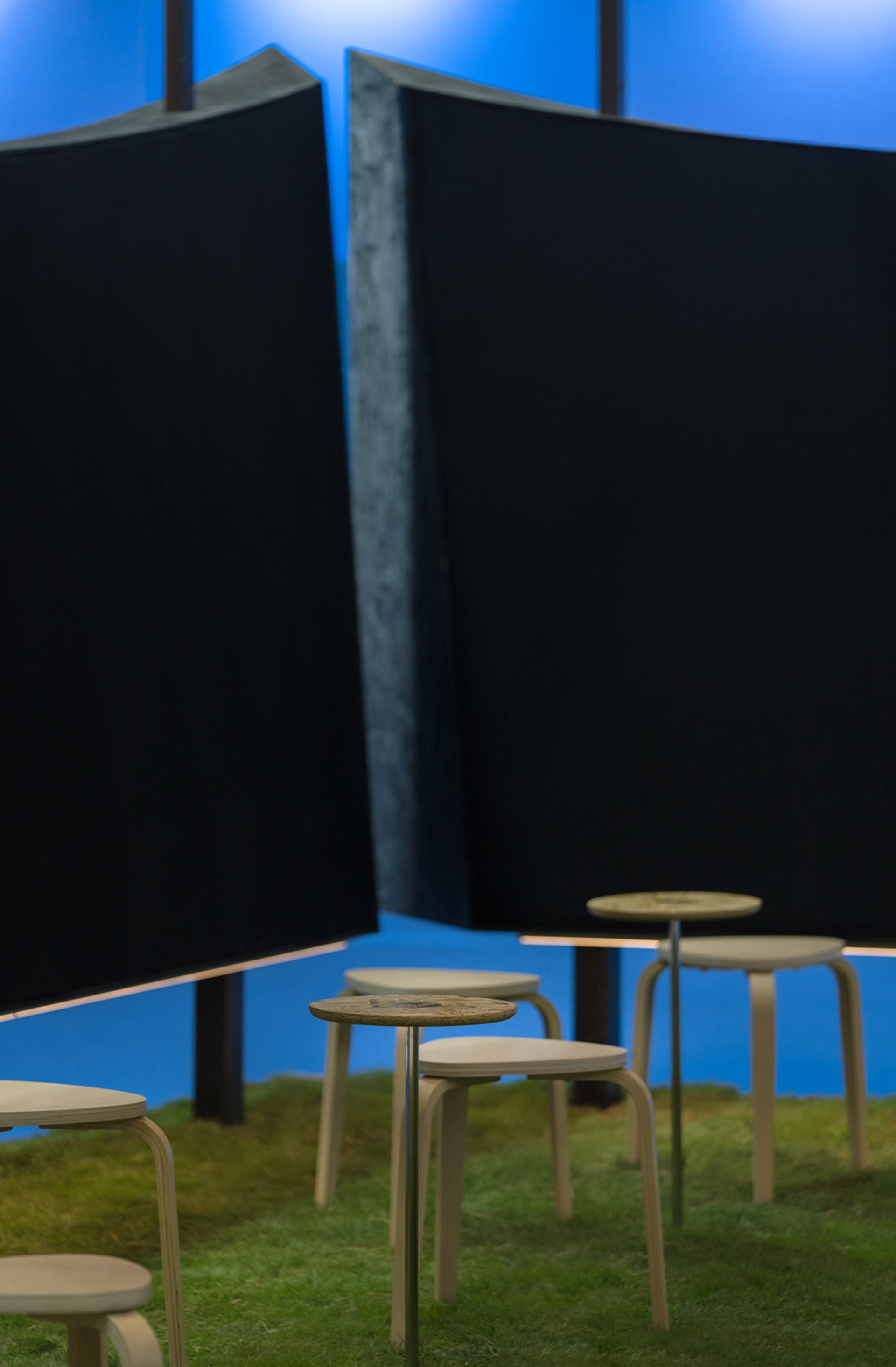 A cozy room with a blue wall, black curtain, a table, and several chairs arranged to create a seating area