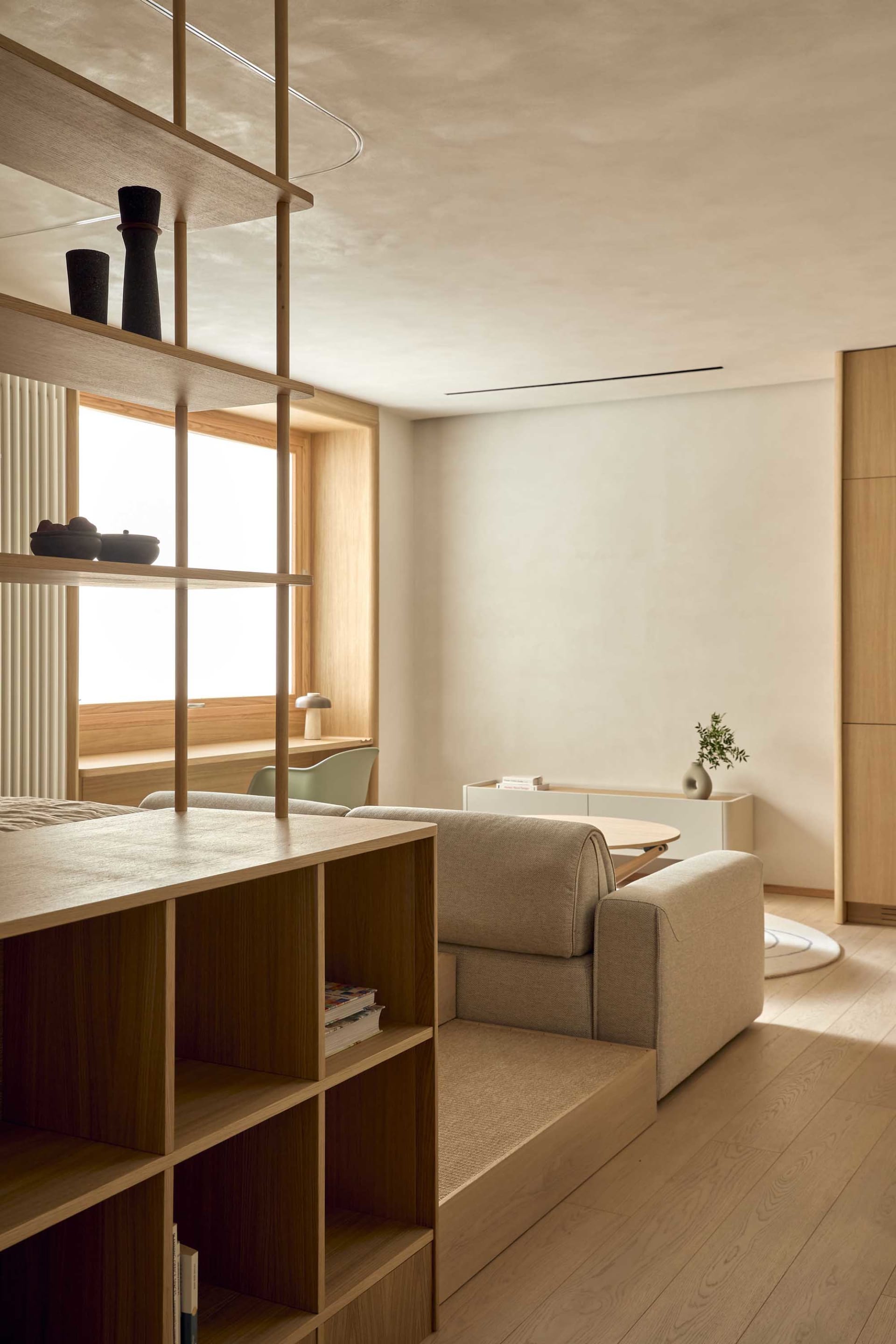 Furnished living room with wooden furniture, a window, and natural light creating a warm atmosphere