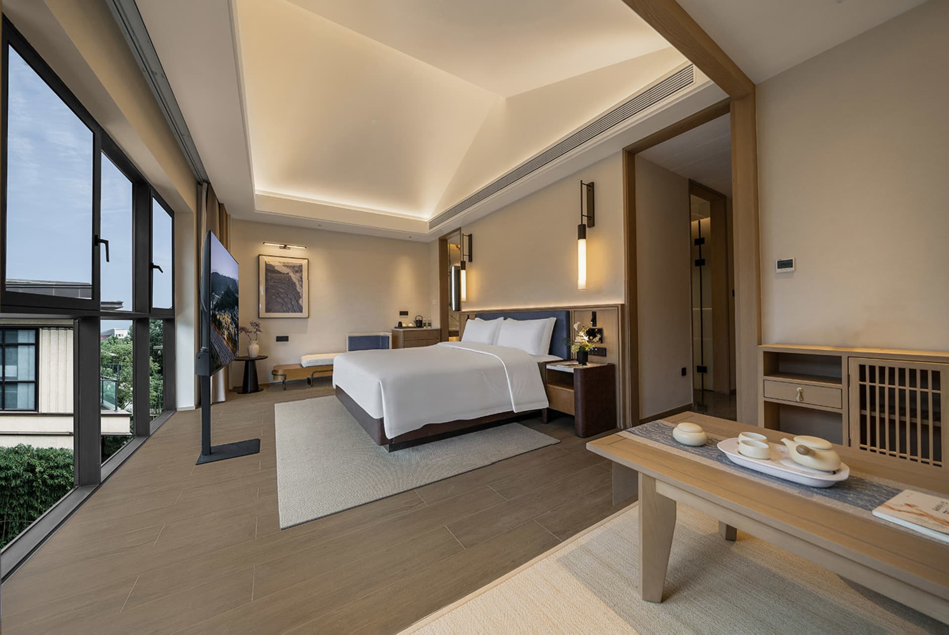 A modern bedroom with a bed, table, and television, featuring wood and glass materials, and a calm and inviting atmosphere