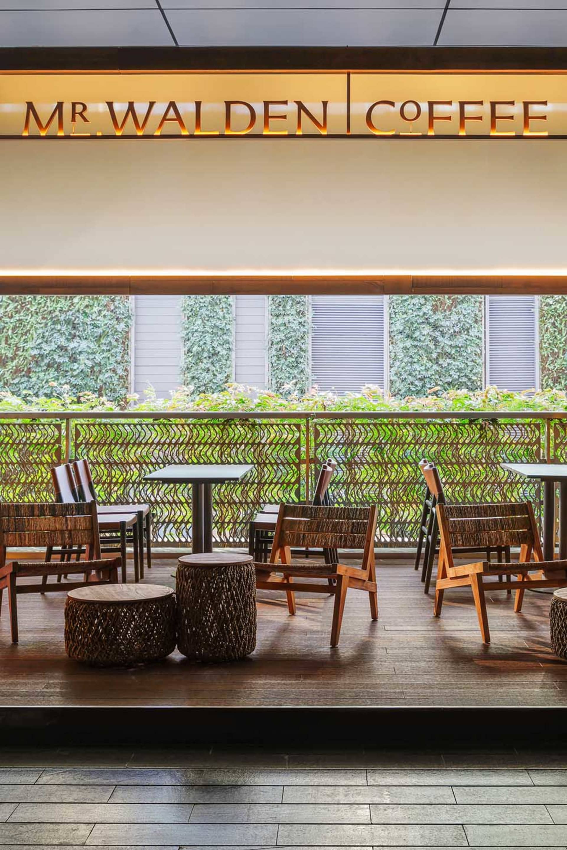 A modern restaurant with a wooden floor, multiple seating options, and soft lighting creating a cozy atmosphere